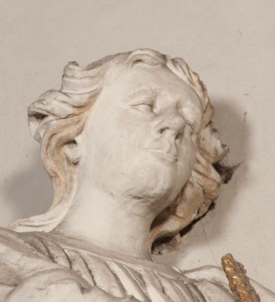 Zdjęcie nr 75: Kaplica pod wezwaniem Najświętszej Marii Panny i Wszystkich Świętych przylega do kościoła od południa, do pierwszego przęsła nawy, z którą komunikuje się za pomocą półkoliście zamkniętej arkady. Zbudowana została na planie kwadratu. Nakryto ją półsferyczną czaszą na pendentywach i zwieńczono latarnią. Wnętrze artykułowano za pomocą ślepej arkady z pilastrami i archiwoltami, ozdobionymi rzeźbioną dekoracją roślinną i kasetonami z rozetami w podłuczu. Ściany kaplicy zamyka wydatne belkowanie z fryzem i łacińską inskrypcją: &quot;DEVS MEVS ET OMNIA / DILEXI DOMINE DECOREM DOMVS / TUAE ET LOCUM HABITATIONIS GLORAE TUAE PSAL(MUS) XXV&quot;. Na czterech pendentywach umieszczono stiukowe kartusze, z czego dwa od strony wschodniej są są puste, a dwa od strony zachodniej wypełniają herby skwadrowane: Gryf, Kotwicz, Kotwicz, Zabawa i Jastrzębiec, Nowina, Gozdawa, Pobóg. Wnętrze doświetlają trzy takie same okulusy umieszczone na każdej ze ścian. Czwarty okulus w ścianie północnej jest zaślepiony. Glify okulusów dekorowane są kasetonami z rozetami. Ściany kaplicy oraz wnętrze kopuły i latarni pokrywa polichromia figuralna. Po arkadą na ścianie wschodniej zawieszono obraz Matki Boskiej z Dzieciątkiem w bogato rzeźbionej roślinno-kwiatowej ramie zwieńczonej godłem z dwiema skrzyżowanymi laskami marszałkowskimi. Pod obrazem znajduje się nagrobek dziecięcy Jana Czuryły (zm. 1560) w formie płaskorzeźbionej, prostokątnej płyty z wyobrażeniem zmarłego. Nad płytą zlokalizowano mniejszą z inskrypcją odnoszącą się do zmarłego. Z kolei wnętrze arkady z herbem Gryf w kluczu na ścianie południowej wypełnia trójosiowy nagrobek Branickich z półokrągłym zwieńczeniem. Natomiast w arkadzie zachodniej wyobrażono scenę Zdjęcia z krzyża w formie malowidła ściennego. Wyposażenie wnętrza dopełniają dwie drewniane ławy kościelne. Ściany zewnętrzne wspierają dwie niskie przypory widoczne w narożach kaplicy. Całość zakończona jest belkowaniem z fryzem zawierającym inskrypcję: &quot;AD LAVDEM DEI OPT(IMO) M(AXIMO) BEATEQUE GENITRICIS MARIAE VIRGINIS ET OMNIUM SANCTORU(M) HONOREM JOHANNES A RVSCZA BRANICZKI VENATOR CRACOVIEN(SIS) ET CAPITANEVS NIEPOLONICEN(SIS) - HANC CAPELLAM EX FVNDAMENTIS EREXIT ANNO D(OMI)NI 1596&quot;. Na ścianie południowej widnieje półokrągła blenda z malowanym przedstawieniem Matki Boskiej Częstochowskiej. Latarnię kaplicy wieńczy głowica z czterema maskami maszkaronów, na której wspiera się złocona kula z krzyżem.