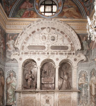 Zdjęcie nr 109: Kaplica pod wezwaniem Najświętszej Marii Panny i Wszystkich Świętych przylega do kościoła od południa, do pierwszego przęsła nawy, z którą komunikuje się za pomocą półkoliście zamkniętej arkady. Zbudowana została na planie kwadratu. Nakryto ją półsferyczną czaszą na pendentywach i zwieńczono latarnią. Wnętrze artykułowano za pomocą ślepej arkady z pilastrami i archiwoltami, ozdobionymi rzeźbioną dekoracją roślinną i kasetonami z rozetami w podłuczu. Ściany kaplicy zamyka wydatne belkowanie z fryzem i łacińską inskrypcją: "DEVS MEVS ET OMNIA / DILEXI DOMINE DECOREM DOMVS / TUAE ET LOCUM HABITATIONIS GLORAE TUAE PSAL(MUS) XXV". Na czterech pendentywach umieszczono stiukowe kartusze, z czego dwa od strony wschodniej są są puste, a dwa od strony zachodniej wypełniają herby skwadrowane: Gryf, Kotwicz, Kotwicz, Zabawa i Jastrzębiec, Nowina, Gozdawa, Pobóg. Wnętrze doświetlają trzy takie same okulusy umieszczone na każdej ze ścian. Czwarty okulus w ścianie północnej jest zaślepiony. Glify okulusów dekorowane są kasetonami z rozetami. Ściany kaplicy oraz wnętrze kopuły i latarni pokrywa polichromia figuralna. Po arkadą na ścianie wschodniej zawieszono obraz Matki Boskiej z Dzieciątkiem w bogato rzeźbionej roślinno-kwiatowej ramie zwieńczonej godłem z dwiema skrzyżowanymi laskami marszałkowskimi. Pod obrazem znajduje się nagrobek dziecięcy Jana Czuryły (zm. 1560) w formie płaskorzeźbionej, prostokątnej płyty z wyobrażeniem zmarłego. Nad płytą zlokalizowano mniejszą z inskrypcją odnoszącą się do zmarłego. Z kolei wnętrze arkady z herbem Gryf w kluczu na ścianie południowej wypełnia trójosiowy nagrobek Branickich z półokrągłym zwieńczeniem. Natomiast w arkadzie zachodniej wyobrażono scenę Zdjęcia z krzyża w formie malowidła ściennego. Wyposażenie wnętrza dopełniają dwie drewniane ławy kościelne. Ściany zewnętrzne wspierają dwie niskie przypory widoczne w narożach kaplicy. Całość zakończona jest belkowaniem z fryzem zawierającym inskrypcję: "AD LAVDEM DEI OPT(IMO) M(AXIMO) BEATEQUE GENITRICIS MARIAE VIRGINIS ET OMNIUM SANCTORU(M) HONOREM JOHANNES A RVSCZA BRANICZKI VENATOR CRACOVIEN(SIS) ET CAPITANEVS NIEPOLONICEN(SIS) - HANC CAPELLAM EX FVNDAMENTIS EREXIT ANNO D(OMI)NI 1596". Na ścianie południowej widnieje półokrągła blenda z malowanym przedstawieniem Matki Boskiej Częstochowskiej. Latarnię kaplicy wieńczy głowica z czterema maskami maszkaronów, na której wspiera się złocona kula z krzyżem.