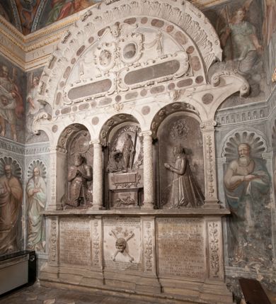 Zdjęcie nr 110: Kaplica pod wezwaniem Najświętszej Marii Panny i Wszystkich Świętych przylega do kościoła od południa, do pierwszego przęsła nawy, z którą komunikuje się za pomocą półkoliście zamkniętej arkady. Zbudowana została na planie kwadratu. Nakryto ją półsferyczną czaszą na pendentywach i zwieńczono latarnią. Wnętrze artykułowano za pomocą ślepej arkady z pilastrami i archiwoltami, ozdobionymi rzeźbioną dekoracją roślinną i kasetonami z rozetami w podłuczu. Ściany kaplicy zamyka wydatne belkowanie z fryzem i łacińską inskrypcją: &quot;DEVS MEVS ET OMNIA / DILEXI DOMINE DECOREM DOMVS / TUAE ET LOCUM HABITATIONIS GLORAE TUAE PSAL(MUS) XXV&quot;. Na czterech pendentywach umieszczono stiukowe kartusze, z czego dwa od strony wschodniej są są puste, a dwa od strony zachodniej wypełniają herby skwadrowane: Gryf, Kotwicz, Kotwicz, Zabawa i Jastrzębiec, Nowina, Gozdawa, Pobóg. Wnętrze doświetlają trzy takie same okulusy umieszczone na każdej ze ścian. Czwarty okulus w ścianie północnej jest zaślepiony. Glify okulusów dekorowane są kasetonami z rozetami. Ściany kaplicy oraz wnętrze kopuły i latarni pokrywa polichromia figuralna. Po arkadą na ścianie wschodniej zawieszono obraz Matki Boskiej z Dzieciątkiem w bogato rzeźbionej roślinno-kwiatowej ramie zwieńczonej godłem z dwiema skrzyżowanymi laskami marszałkowskimi. Pod obrazem znajduje się nagrobek dziecięcy Jana Czuryły (zm. 1560) w formie płaskorzeźbionej, prostokątnej płyty z wyobrażeniem zmarłego. Nad płytą zlokalizowano mniejszą z inskrypcją odnoszącą się do zmarłego. Z kolei wnętrze arkady z herbem Gryf w kluczu na ścianie południowej wypełnia trójosiowy nagrobek Branickich z półokrągłym zwieńczeniem. Natomiast w arkadzie zachodniej wyobrażono scenę Zdjęcia z krzyża w formie malowidła ściennego. Wyposażenie wnętrza dopełniają dwie drewniane ławy kościelne. Ściany zewnętrzne wspierają dwie niskie przypory widoczne w narożach kaplicy. Całość zakończona jest belkowaniem z fryzem zawierającym inskrypcję: &quot;AD LAVDEM DEI OPT(IMO) M(AXIMO) BEATEQUE GENITRICIS MARIAE VIRGINIS ET OMNIUM SANCTORU(M) HONOREM JOHANNES A RVSCZA BRANICZKI VENATOR CRACOVIEN(SIS) ET CAPITANEVS NIEPOLONICEN(SIS) - HANC CAPELLAM EX FVNDAMENTIS EREXIT ANNO D(OMI)NI 1596&quot;. Na ścianie południowej widnieje półokrągła blenda z malowanym przedstawieniem Matki Boskiej Częstochowskiej. Latarnię kaplicy wieńczy głowica z czterema maskami maszkaronów, na której wspiera się złocona kula z krzyżem.