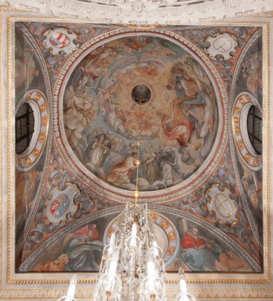 Zdjęcie nr 113: Kaplica pod wezwaniem Najświętszej Marii Panny i Wszystkich Świętych przylega do kościoła od południa, do pierwszego przęsła nawy, z którą komunikuje się za pomocą półkoliście zamkniętej arkady. Zbudowana została na planie kwadratu. Nakryto ją półsferyczną czaszą na pendentywach i zwieńczono latarnią. Wnętrze artykułowano za pomocą ślepej arkady z pilastrami i archiwoltami, ozdobionymi rzeźbioną dekoracją roślinną i kasetonami z rozetami w podłuczu. Ściany kaplicy zamyka wydatne belkowanie z fryzem i łacińską inskrypcją: "DEVS MEVS ET OMNIA / DILEXI DOMINE DECOREM DOMVS / TUAE ET LOCUM HABITATIONIS GLORAE TUAE PSAL(MUS) XXV". Na czterech pendentywach umieszczono stiukowe kartusze, z czego dwa od strony wschodniej są są puste, a dwa od strony zachodniej wypełniają herby skwadrowane: Gryf, Kotwicz, Kotwicz, Zabawa i Jastrzębiec, Nowina, Gozdawa, Pobóg. Wnętrze doświetlają trzy takie same okulusy umieszczone na każdej ze ścian. Czwarty okulus w ścianie północnej jest zaślepiony. Glify okulusów dekorowane są kasetonami z rozetami. Ściany kaplicy oraz wnętrze kopuły i latarni pokrywa polichromia figuralna. Po arkadą na ścianie wschodniej zawieszono obraz Matki Boskiej z Dzieciątkiem w bogato rzeźbionej roślinno-kwiatowej ramie zwieńczonej godłem z dwiema skrzyżowanymi laskami marszałkowskimi. Pod obrazem znajduje się nagrobek dziecięcy Jana Czuryły (zm. 1560) w formie płaskorzeźbionej, prostokątnej płyty z wyobrażeniem zmarłego. Nad płytą zlokalizowano mniejszą z inskrypcją odnoszącą się do zmarłego. Z kolei wnętrze arkady z herbem Gryf w kluczu na ścianie południowej wypełnia trójosiowy nagrobek Branickich z półokrągłym zwieńczeniem. Natomiast w arkadzie zachodniej wyobrażono scenę Zdjęcia z krzyża w formie malowidła ściennego. Wyposażenie wnętrza dopełniają dwie drewniane ławy kościelne. Ściany zewnętrzne wspierają dwie niskie przypory widoczne w narożach kaplicy. Całość zakończona jest belkowaniem z fryzem zawierającym inskrypcję: "AD LAVDEM DEI OPT(IMO) M(AXIMO) BEATEQUE GENITRICIS MARIAE VIRGINIS ET OMNIUM SANCTORU(M) HONOREM JOHANNES A RVSCZA BRANICZKI VENATOR CRACOVIEN(SIS) ET CAPITANEVS NIEPOLONICEN(SIS) - HANC CAPELLAM EX FVNDAMENTIS EREXIT ANNO D(OMI)NI 1596". Na ścianie południowej widnieje półokrągła blenda z malowanym przedstawieniem Matki Boskiej Częstochowskiej. Latarnię kaplicy wieńczy głowica z czterema maskami maszkaronów, na której wspiera się złocona kula z krzyżem.