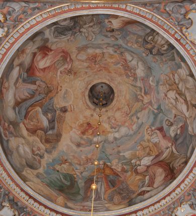 Zdjęcie nr 114: Kaplica pod wezwaniem Najświętszej Marii Panny i Wszystkich Świętych przylega do kościoła od południa, do pierwszego przęsła nawy, z którą komunikuje się za pomocą półkoliście zamkniętej arkady. Zbudowana została na planie kwadratu. Nakryto ją półsferyczną czaszą na pendentywach i zwieńczono latarnią. Wnętrze artykułowano za pomocą ślepej arkady z pilastrami i archiwoltami, ozdobionymi rzeźbioną dekoracją roślinną i kasetonami z rozetami w podłuczu. Ściany kaplicy zamyka wydatne belkowanie z fryzem i łacińską inskrypcją: "DEVS MEVS ET OMNIA / DILEXI DOMINE DECOREM DOMVS / TUAE ET LOCUM HABITATIONIS GLORAE TUAE PSAL(MUS) XXV". Na czterech pendentywach umieszczono stiukowe kartusze, z czego dwa od strony wschodniej są są puste, a dwa od strony zachodniej wypełniają herby skwadrowane: Gryf, Kotwicz, Kotwicz, Zabawa i Jastrzębiec, Nowina, Gozdawa, Pobóg. Wnętrze doświetlają trzy takie same okulusy umieszczone na każdej ze ścian. Czwarty okulus w ścianie północnej jest zaślepiony. Glify okulusów dekorowane są kasetonami z rozetami. Ściany kaplicy oraz wnętrze kopuły i latarni pokrywa polichromia figuralna. Po arkadą na ścianie wschodniej zawieszono obraz Matki Boskiej z Dzieciątkiem w bogato rzeźbionej roślinno-kwiatowej ramie zwieńczonej godłem z dwiema skrzyżowanymi laskami marszałkowskimi. Pod obrazem znajduje się nagrobek dziecięcy Jana Czuryły (zm. 1560) w formie płaskorzeźbionej, prostokątnej płyty z wyobrażeniem zmarłego. Nad płytą zlokalizowano mniejszą z inskrypcją odnoszącą się do zmarłego. Z kolei wnętrze arkady z herbem Gryf w kluczu na ścianie południowej wypełnia trójosiowy nagrobek Branickich z półokrągłym zwieńczeniem. Natomiast w arkadzie zachodniej wyobrażono scenę Zdjęcia z krzyża w formie malowidła ściennego. Wyposażenie wnętrza dopełniają dwie drewniane ławy kościelne. Ściany zewnętrzne wspierają dwie niskie przypory widoczne w narożach kaplicy. Całość zakończona jest belkowaniem z fryzem zawierającym inskrypcję: "AD LAVDEM DEI OPT(IMO) M(AXIMO) BEATEQUE GENITRICIS MARIAE VIRGINIS ET OMNIUM SANCTORU(M) HONOREM JOHANNES A RVSCZA BRANICZKI VENATOR CRACOVIEN(SIS) ET CAPITANEVS NIEPOLONICEN(SIS) - HANC CAPELLAM EX FVNDAMENTIS EREXIT ANNO D(OMI)NI 1596". Na ścianie południowej widnieje półokrągła blenda z malowanym przedstawieniem Matki Boskiej Częstochowskiej. Latarnię kaplicy wieńczy głowica z czterema maskami maszkaronów, na której wspiera się złocona kula z krzyżem.