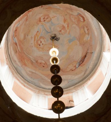 Zdjęcie nr 18: Kaplica pod wezwaniem Najświętszej Marii Panny i Wszystkich Świętych przylega do kościoła od południa, do pierwszego przęsła nawy, z którą komunikuje się za pomocą półkoliście zamkniętej arkady. Zbudowana została na planie kwadratu. Nakryto ją półsferyczną czaszą na pendentywach i zwieńczono latarnią. Wnętrze artykułowano za pomocą ślepej arkady z pilastrami i archiwoltami, ozdobionymi rzeźbioną dekoracją roślinną i kasetonami z rozetami w podłuczu. Ściany kaplicy zamyka wydatne belkowanie z fryzem i łacińską inskrypcją: &quot;DEVS MEVS ET OMNIA / DILEXI DOMINE DECOREM DOMVS / TUAE ET LOCUM HABITATIONIS GLORAE TUAE PSAL(MUS) XXV&quot;. Na czterech pendentywach umieszczono stiukowe kartusze, z czego dwa od strony wschodniej są są puste, a dwa od strony zachodniej wypełniają herby skwadrowane: Gryf, Kotwicz, Kotwicz, Zabawa i Jastrzębiec, Nowina, Gozdawa, Pobóg. Wnętrze doświetlają trzy takie same okulusy umieszczone na każdej ze ścian. Czwarty okulus w ścianie północnej jest zaślepiony. Glify okulusów dekorowane są kasetonami z rozetami. Ściany kaplicy oraz wnętrze kopuły i latarni pokrywa polichromia figuralna. Po arkadą na ścianie wschodniej zawieszono obraz Matki Boskiej z Dzieciątkiem w bogato rzeźbionej roślinno-kwiatowej ramie zwieńczonej godłem z dwiema skrzyżowanymi laskami marszałkowskimi. Pod obrazem znajduje się nagrobek dziecięcy Jana Czuryły (zm. 1560) w formie płaskorzeźbionej, prostokątnej płyty z wyobrażeniem zmarłego. Nad płytą zlokalizowano mniejszą z inskrypcją odnoszącą się do zmarłego. Z kolei wnętrze arkady z herbem Gryf w kluczu na ścianie południowej wypełnia trójosiowy nagrobek Branickich z półokrągłym zwieńczeniem. Natomiast w arkadzie zachodniej wyobrażono scenę Zdjęcia z krzyża w formie malowidła ściennego. Wyposażenie wnętrza dopełniają dwie drewniane ławy kościelne. Ściany zewnętrzne wspierają dwie niskie przypory widoczne w narożach kaplicy. Całość zakończona jest belkowaniem z fryzem zawierającym inskrypcję: &quot;AD LAVDEM DEI OPT(IMO) M(AXIMO) BEATEQUE GENITRICIS MARIAE VIRGINIS ET OMNIUM SANCTORU(M) HONOREM JOHANNES A RVSCZA BRANICZKI VENATOR CRACOVIEN(SIS) ET CAPITANEVS NIEPOLONICEN(SIS) - HANC CAPELLAM EX FVNDAMENTIS EREXIT ANNO D(OMI)NI 1596&quot;. Na ścianie południowej widnieje półokrągła blenda z malowanym przedstawieniem Matki Boskiej Częstochowskiej. Latarnię kaplicy wieńczy głowica z czterema maskami maszkaronów, na której wspiera się złocona kula z krzyżem.