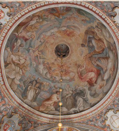 Zdjęcie nr 21: Kaplica pod wezwaniem Najświętszej Marii Panny i Wszystkich Świętych przylega do kościoła od południa, do pierwszego przęsła nawy, z którą komunikuje się za pomocą półkoliście zamkniętej arkady. Zbudowana została na planie kwadratu. Nakryto ją półsferyczną czaszą na pendentywach i zwieńczono latarnią. Wnętrze artykułowano za pomocą ślepej arkady z pilastrami i archiwoltami, ozdobionymi rzeźbioną dekoracją roślinną i kasetonami z rozetami w podłuczu. Ściany kaplicy zamyka wydatne belkowanie z fryzem i łacińską inskrypcją: "DEVS MEVS ET OMNIA / DILEXI DOMINE DECOREM DOMVS / TUAE ET LOCUM HABITATIONIS GLORAE TUAE PSAL(MUS) XXV". Na czterech pendentywach umieszczono stiukowe kartusze, z czego dwa od strony wschodniej są są puste, a dwa od strony zachodniej wypełniają herby skwadrowane: Gryf, Kotwicz, Kotwicz, Zabawa i Jastrzębiec, Nowina, Gozdawa, Pobóg. Wnętrze doświetlają trzy takie same okulusy umieszczone na każdej ze ścian. Czwarty okulus w ścianie północnej jest zaślepiony. Glify okulusów dekorowane są kasetonami z rozetami. Ściany kaplicy oraz wnętrze kopuły i latarni pokrywa polichromia figuralna. Po arkadą na ścianie wschodniej zawieszono obraz Matki Boskiej z Dzieciątkiem w bogato rzeźbionej roślinno-kwiatowej ramie zwieńczonej godłem z dwiema skrzyżowanymi laskami marszałkowskimi. Pod obrazem znajduje się nagrobek dziecięcy Jana Czuryły (zm. 1560) w formie płaskorzeźbionej, prostokątnej płyty z wyobrażeniem zmarłego. Nad płytą zlokalizowano mniejszą z inskrypcją odnoszącą się do zmarłego. Z kolei wnętrze arkady z herbem Gryf w kluczu na ścianie południowej wypełnia trójosiowy nagrobek Branickich z półokrągłym zwieńczeniem. Natomiast w arkadzie zachodniej wyobrażono scenę Zdjęcia z krzyża w formie malowidła ściennego. Wyposażenie wnętrza dopełniają dwie drewniane ławy kościelne. Ściany zewnętrzne wspierają dwie niskie przypory widoczne w narożach kaplicy. Całość zakończona jest belkowaniem z fryzem zawierającym inskrypcję: "AD LAVDEM DEI OPT(IMO) M(AXIMO) BEATEQUE GENITRICIS MARIAE VIRGINIS ET OMNIUM SANCTORU(M) HONOREM JOHANNES A RVSCZA BRANICZKI VENATOR CRACOVIEN(SIS) ET CAPITANEVS NIEPOLONICEN(SIS) - HANC CAPELLAM EX FVNDAMENTIS EREXIT ANNO D(OMI)NI 1596". Na ścianie południowej widnieje półokrągła blenda z malowanym przedstawieniem Matki Boskiej Częstochowskiej. Latarnię kaplicy wieńczy głowica z czterema maskami maszkaronów, na której wspiera się złocona kula z krzyżem.