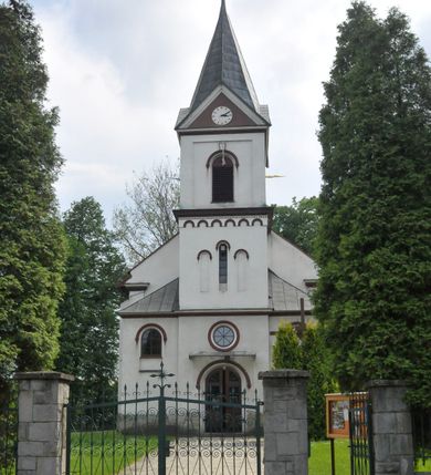 Zdjęcie nr 2: Kościół jest usytuowany w centrum wsi Łękawica, na południe od głównej drogi. Teren wokół niego jest ogrodzony wysokim płotem na kamiennej podmurówce. Główne wejście na teren przykościelny znajduje się w murze od zachodu z bramką i dwiema furtkami.

Kościół skierowany na południe, murowany, otynkowany z wieżą od północy. Wnętrze świątyni tworzy niewielkie, prostokątne, jednoprzęsłowe prezbiterium zakończone trójbocznie. Nawa jest szersza, na planie prostokąta, oddzielona od prezbiterium szeroką, półkoliście zamkniętą arkadą w ścianie tęczowej. Od wschodu do prezbiterium przylega założona na planie prostokąta niewielka zakrystia, a od zachodu do nawy niewielka kruchta. Na północnej ścianie kościoła chór muzyczny, wzniesiony nad kruchtą wejściową. Nawę oświetlają umieszczone we wschodnich i zachodnich ścianach prostokątne, zamknięte półkoliście okna, po trzy z każdej strony. Wszystkie otwory okienne w kościele wypełnione są witrażami. Do świątyni prowadzą trzy wejścia: główne od strony północnej, drugie przez kruchtę zachodnią oraz trzecie przez zakrystię. Wejście główne prowadzi poprzez dwuskrzydłowe drzwi z kruchty pod wieżą. 

W zewnętrznej elewacji kościoła widoczny jest niewysoki, kamienny cokół, wykonany z nieregularnych ciosów kamienia. Prezbiterium niższe od nawy. Ściany nawy oszkarpowane. Do północnej fasady kościoła dostawiona jest założona na planie kwadratu trójkondygnacyjna wieża-dzwonnica oraz dostawione po bokach dwa aneksy, sięgające wysokością do końca pierwszej kondygnacji wieży. Poszczególne kondygnacje rozdzielone są gzymsami. W dolnej kondygnacji na osi kościoła, prostokątne wejście do kruchty, zamknięte półkoliście, zaakcentowane półkolistym nadprożem. Powyżej ażurowym, metalowy daszek oraz okrągłe, rozglifione okno. W drugiej kondygnacji ślepe triforium z przeszkolnym oknem pośrodku i blendami po bokach. Powyżej kondygnacja z trzech stron zdobiona półkolistym arkadowaniem, wyżej kostkowaniem. W trzeciej kondygnacji, w każdej ze ścian prostokątne zamknięte półkoliście prześwity okienne z żaluzjami. Całość nakryta ośmiobocznym, smukłym dachem wieżowym, zakończonym krzyżem osadzonym na kuli; u dołu artykułowanym czterema trójkątnymi przyczółkami, w polach których umieszczone są zegary. Aneksy na planie kwadratu z prostokątnymi i półkoliście zamkniętymi oknami od frontu. Prezbiterium i nawa przykryte oddzielnie, stromymi dachami dwuspadowymi. 