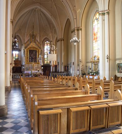 Zdjęcie nr 80: Kościół z cegły i kamienia. Na rzucie krzyża łacińskiego, jednonawowy z wciągniętymi do wnętrza przyporami. Prezbiterium krótkie, zamknięte pięcioma bokami ośmioboku. Korpus jednonawowy, czteroprzęsłowy, po bokach z płytkimi wnękami-kaplicami pomiędzy przyporami, poprzedzony od zach. przedsionkiem. Do pierwszego przęsła dostawione dwie symetryczne, trójboczne kaplice, nad nimi dwie czworoboczne wieże. Zakrystia przy prezbiterium na osi kościoła. Artykulacja ścian wnętrza za pomocą filarów opiętych półkolumnami z kapitelami z motywów liści. Między filarami rozpięte ostrołukowe arkady tworzące płytkie wnęki. Pierwsze przęsło wyróżnione przy pomocy masywnych filarów, ujętych niemal pełnoplastycznymi kolumnami. Okna ostrołukowe, dwudzielne z maswerkami, wsparte na gzymsach. Sklepienia krzyżowo-żebrowe na zaostrzonych gurtach. Kaplice artykułowane analogicznie do nawy kościoła, ze sklepieniami gwiaździstymi. Przedsionek otwiera się do kościoła trzema portalami ostrołukowymi opiętymi kolumnami. W polach archiwolt płaskorzeźby: Boże Narodzenie, Ukrzyżowanie, Wniebowstąpienie (K. Ceptowski).  W prezbiterium, na osi kościoła prostokątny otwór drzwiowy prowadzący do zakrystii. Chór muzyczny umieszczony nad kruchtą kościoła, na rzucie prostokąta, z kamienną balustradą maswerkową. Fasada kamienna, trójosiowa, zamknięta trójkątnie, flankowana lizenami przechodzącymi w ażurowe wieżyczki-latarnie, na rzucie kwadratu. Wieżyczki zwieńczone gzymsem i balustradą arkadową, hełmy ostrosłupowy zakończony iglicą. W dolnej części trzy filarowe arkady ostrołukowe, otwierające się do kruchty, sklepienie kruchty krzyżowo-żebrowe. Nad arkadami wejściowymi trzy tonda: litery IHS, Oko Opatrzności i splecione litery imienia Maria. Pośrodku na osi kościoła duża rozeta z maswerkiem, profilowana, otoczona pierścieniem wypełnionym stylizowanym ornamentem roślinnym. Ponad arkadami pełnoplastyczne figury czterech ewangelistów ustawionych na konsolach z rzeźbionymi atrybutami (F. Kuhn). Po bokach rozety prostokątne płyciny z traczami herbowymi Potockich i Branickich. U góry, na osi fasady figura Archanioła Michała. Elewacje na kamiennym cokole, z gzymsem kapnikowym, opięte prostokątnymi przyporami zwieńczonymi kamiennymi nakrywami. W górnej części kamienny fryz arkadkowy. Nad nim gzyms koronujący podtrzymujący ażurową, arkadową balustradę. Przy prezbiterium kaplice zamknięte trójbocznie, prezbiterium zamknięte pięciobocznie. Zakrystia na osi prezbiterium, na rzucie prostokąta, zwieńczona sygnaturką i ceglanym kominem. Po bokach prostokątne aneksy, południowy aneks - trzy okna ostrołukowe w kamiennej opasce, w środkowym przedstawienie Ukrzyżowanego Chrystusa. W północnym aneksie pojedyncze analogiczne okno. Okna ostrołukowe w profilowanych kamiennych opaskach, pomiędzy nimi a gzymsem koronującym mniejsze ostrołukowe w uskokowych arkadach. Nad kaplicami bocznymi dwie symetryczne wieże na rzucie kwadratu, w połowie wysokości kamienny gzyms z fryzem arkadkowym. Okna ostrołukowe w kamiennej opasce. Całość zwieńczona ślepym fryzem arkadkowym, wyżej gzyms dźwigający ażurową arkadkową balustradę. Hełmy ostrosłupowe, miedziane. Zakrystia na rzucie prostokąta, nakryta sklepieniem kolebkowym zaostrzonym i krzyżowym z lunetami , oddzielone gurtem. Portale od wschodu i zachodu prostokątne zamknięte łukiem ostrym. Okna ostrołukowe.