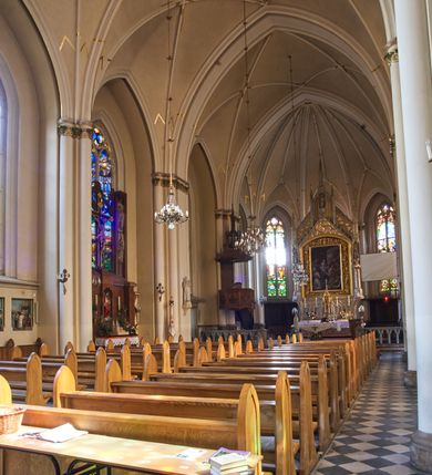 Zdjęcie nr 81: Kościół z cegły i kamienia. Na rzucie krzyża łacińskiego, jednonawowy z wciągniętymi do wnętrza przyporami. Prezbiterium krótkie, zamknięte pięcioma bokami ośmioboku. Korpus jednonawowy, czteroprzęsłowy, po bokach z płytkimi wnękami-kaplicami pomiędzy przyporami, poprzedzony od zach. przedsionkiem. Do pierwszego przęsła dostawione dwie symetryczne, trójboczne kaplice, nad nimi dwie czworoboczne wieże. Zakrystia przy prezbiterium na osi kościoła. Artykulacja ścian wnętrza za pomocą filarów opiętych półkolumnami z kapitelami z motywów liści. Między filarami rozpięte ostrołukowe arkady tworzące płytkie wnęki. Pierwsze przęsło wyróżnione przy pomocy masywnych filarów, ujętych niemal pełnoplastycznymi kolumnami. Okna ostrołukowe, dwudzielne z maswerkami, wsparte na gzymsach. Sklepienia krzyżowo-żebrowe na zaostrzonych gurtach. Kaplice artykułowane analogicznie do nawy kościoła, ze sklepieniami gwiaździstymi. Przedsionek otwiera się do kościoła trzema portalami ostrołukowymi opiętymi kolumnami. W polach archiwolt płaskorzeźby: Boże Narodzenie, Ukrzyżowanie, Wniebowstąpienie (K. Ceptowski).  W prezbiterium, na osi kościoła prostokątny otwór drzwiowy prowadzący do zakrystii. Chór muzyczny umieszczony nad kruchtą kościoła, na rzucie prostokąta, z kamienną balustradą maswerkową. Fasada kamienna, trójosiowa, zamknięta trójkątnie, flankowana lizenami przechodzącymi w ażurowe wieżyczki-latarnie, na rzucie kwadratu. Wieżyczki zwieńczone gzymsem i balustradą arkadową, hełmy ostrosłupowy zakończony iglicą. W dolnej części trzy filarowe arkady ostrołukowe, otwierające się do kruchty, sklepienie kruchty krzyżowo-żebrowe. Nad arkadami wejściowymi trzy tonda: litery IHS, Oko Opatrzności i splecione litery imienia Maria. Pośrodku na osi kościoła duża rozeta z maswerkiem, profilowana, otoczona pierścieniem wypełnionym stylizowanym ornamentem roślinnym. Ponad arkadami pełnoplastyczne figury czterech ewangelistów ustawionych na konsolach z rzeźbionymi atrybutami (F. Kuhn). Po bokach rozety prostokątne płyciny z traczami herbowymi Potockich i Branickich. U góry, na osi fasady figura Archanioła Michała. Elewacje na kamiennym cokole, z gzymsem kapnikowym, opięte prostokątnymi przyporami zwieńczonymi kamiennymi nakrywami. W górnej części kamienny fryz arkadkowy. Nad nim gzyms koronujący podtrzymujący ażurową, arkadową balustradę. Przy prezbiterium kaplice zamknięte trójbocznie, prezbiterium zamknięte pięciobocznie. Zakrystia na osi prezbiterium, na rzucie prostokąta, zwieńczona sygnaturką i ceglanym kominem. Po bokach prostokątne aneksy, południowy aneks - trzy okna ostrołukowe w kamiennej opasce, w środkowym przedstawienie Ukrzyżowanego Chrystusa. W północnym aneksie pojedyncze analogiczne okno. Okna ostrołukowe w profilowanych kamiennych opaskach, pomiędzy nimi a gzymsem koronującym mniejsze ostrołukowe w uskokowych arkadach. Nad kaplicami bocznymi dwie symetryczne wieże na rzucie kwadratu, w połowie wysokości kamienny gzyms z fryzem arkadkowym. Okna ostrołukowe w kamiennej opasce. Całość zwieńczona ślepym fryzem arkadkowym, wyżej gzyms dźwigający ażurową arkadkową balustradę. Hełmy ostrosłupowe, miedziane. Zakrystia na rzucie prostokąta, nakryta sklepieniem kolebkowym zaostrzonym i krzyżowym z lunetami , oddzielone gurtem. Portale od wschodu i zachodu prostokątne zamknięte łukiem ostrym. Okna ostrołukowe.