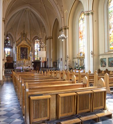 Zdjęcie nr 78: Kościół z cegły i kamienia. Na rzucie krzyża łacińskiego, jednonawowy z wciągniętymi do wnętrza przyporami. Prezbiterium krótkie, zamknięte pięcioma bokami ośmioboku. Korpus jednonawowy, czteroprzęsłowy, po bokach z płytkimi wnękami-kaplicami pomiędzy przyporami, poprzedzony od zach. przedsionkiem. Do pierwszego przęsła dostawione dwie symetryczne, trójboczne kaplice, nad nimi dwie czworoboczne wieże. Zakrystia przy prezbiterium na osi kościoła. Artykulacja ścian wnętrza za pomocą filarów opiętych półkolumnami z kapitelami z motywów liści. Między filarami rozpięte ostrołukowe arkady tworzące płytkie wnęki. Pierwsze przęsło wyróżnione przy pomocy masywnych filarów, ujętych niemal pełnoplastycznymi kolumnami. Okna ostrołukowe, dwudzielne z maswerkami, wsparte na gzymsach. Sklepienia krzyżowo-żebrowe na zaostrzonych gurtach. Kaplice artykułowane analogicznie do nawy kościoła, ze sklepieniami gwiaździstymi. Przedsionek otwiera się do kościoła trzema portalami ostrołukowymi opiętymi kolumnami. W polach archiwolt płaskorzeźby: Boże Narodzenie, Ukrzyżowanie, Wniebowstąpienie (K. Ceptowski).  W prezbiterium, na osi kościoła prostokątny otwór drzwiowy prowadzący do zakrystii. Chór muzyczny umieszczony nad kruchtą kościoła, na rzucie prostokąta, z kamienną balustradą maswerkową. Fasada kamienna, trójosiowa, zamknięta trójkątnie, flankowana lizenami przechodzącymi w ażurowe wieżyczki-latarnie, na rzucie kwadratu. Wieżyczki zwieńczone gzymsem i balustradą arkadową, hełmy ostrosłupowy zakończony iglicą. W dolnej części trzy filarowe arkady ostrołukowe, otwierające się do kruchty, sklepienie kruchty krzyżowo-żebrowe. Nad arkadami wejściowymi trzy tonda: litery IHS, Oko Opatrzności i splecione litery imienia Maria. Pośrodku na osi kościoła duża rozeta z maswerkiem, profilowana, otoczona pierścieniem wypełnionym stylizowanym ornamentem roślinnym. Ponad arkadami pełnoplastyczne figury czterech ewangelistów ustawionych na konsolach z rzeźbionymi atrybutami (F. Kuhn). Po bokach rozety prostokątne płyciny z traczami herbowymi Potockich i Branickich. U góry, na osi fasady figura Archanioła Michała. Elewacje na kamiennym cokole, z gzymsem kapnikowym, opięte prostokątnymi przyporami zwieńczonymi kamiennymi nakrywami. W górnej części kamienny fryz arkadkowy. Nad nim gzyms koronujący podtrzymujący ażurową, arkadową balustradę. Przy prezbiterium kaplice zamknięte trójbocznie, prezbiterium zamknięte pięciobocznie. Zakrystia na osi prezbiterium, na rzucie prostokąta, zwieńczona sygnaturką i ceglanym kominem. Po bokach prostokątne aneksy, południowy aneks - trzy okna ostrołukowe w kamiennej opasce, w środkowym przedstawienie Ukrzyżowanego Chrystusa. W północnym aneksie pojedyncze analogiczne okno. Okna ostrołukowe w profilowanych kamiennych opaskach, pomiędzy nimi a gzymsem koronującym mniejsze ostrołukowe w uskokowych arkadach. Nad kaplicami bocznymi dwie symetryczne wieże na rzucie kwadratu, w połowie wysokości kamienny gzyms z fryzem arkadkowym. Okna ostrołukowe w kamiennej opasce. Całość zwieńczona ślepym fryzem arkadkowym, wyżej gzyms dźwigający ażurową arkadkową balustradę. Hełmy ostrosłupowe, miedziane. Zakrystia na rzucie prostokąta, nakryta sklepieniem kolebkowym zaostrzonym i krzyżowym z lunetami , oddzielone gurtem. Portale od wschodu i zachodu prostokątne zamknięte łukiem ostrym. Okna ostrołukowe.