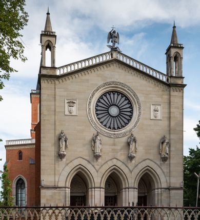 Zdjęcie nr 2: Kościół z cegły i kamienia. Na rzucie krzyża łacińskiego, jednonawowy z wciągniętymi do wnętrza przyporami. Prezbiterium krótkie, zamknięte pięcioma bokami ośmioboku. Korpus jednonawowy, czteroprzęsłowy, po bokach z płytkimi wnękami-kaplicami pomiędzy przyporami, poprzedzony od zach. przedsionkiem. Do pierwszego przęsła dostawione dwie symetryczne, trójboczne kaplice, nad nimi dwie czworoboczne wieże. Zakrystia przy prezbiterium na osi kościoła. Artykulacja ścian wnętrza za pomocą filarów opiętych półkolumnami z kapitelami z motywów liści. Między filarami rozpięte ostrołukowe arkady tworzące płytkie wnęki. Pierwsze przęsło wyróżnione przy pomocy masywnych filarów, ujętych niemal pełnoplastycznymi kolumnami. Okna ostrołukowe, dwudzielne z maswerkami, wsparte na gzymsach. Sklepienia krzyżowo-żebrowe na zaostrzonych gurtach. Kaplice artykułowane analogicznie do nawy kościoła, ze sklepieniami gwiaździstymi. Przedsionek otwiera się do kościoła trzema portalami ostrołukowymi opiętymi kolumnami. W polach archiwolt płaskorzeźby: Boże Narodzenie, Ukrzyżowanie, Wniebowstąpienie (K. Ceptowski).  W prezbiterium, na osi kościoła prostokątny otwór drzwiowy prowadzący do zakrystii. Chór muzyczny umieszczony nad kruchtą kościoła, na rzucie prostokąta, z kamienną balustradą maswerkową. Fasada kamienna, trójosiowa, zamknięta trójkątnie, flankowana lizenami przechodzącymi w ażurowe wieżyczki-latarnie, na rzucie kwadratu. Wieżyczki zwieńczone gzymsem i balustradą arkadową, hełmy ostrosłupowy zakończony iglicą. W dolnej części trzy filarowe arkady ostrołukowe, otwierające się do kruchty, sklepienie kruchty krzyżowo-żebrowe. Nad arkadami wejściowymi trzy tonda: litery IHS, Oko Opatrzności i splecione litery imienia Maria. Pośrodku na osi kościoła duża rozeta z maswerkiem, profilowana, otoczona pierścieniem wypełnionym stylizowanym ornamentem roślinnym. Ponad arkadami pełnoplastyczne figury czterech ewangelistów ustawionych na konsolach z rzeźbionymi atrybutami (F. Kuhn). Po bokach rozety prostokątne płyciny z traczami herbowymi Potockich i Branickich. U góry, na osi fasady figura Archanioła Michała. Elewacje na kamiennym cokole, z gzymsem kapnikowym, opięte prostokątnymi przyporami zwieńczonymi kamiennymi nakrywami. W górnej części kamienny fryz arkadkowy. Nad nim gzyms koronujący podtrzymujący ażurową, arkadową balustradę. Przy prezbiterium kaplice zamknięte trójbocznie, prezbiterium zamknięte pięciobocznie. Zakrystia na osi prezbiterium, na rzucie prostokąta, zwieńczona sygnaturką i ceglanym kominem. Po bokach prostokątne aneksy, południowy aneks - trzy okna ostrołukowe w kamiennej opasce, w środkowym przedstawienie Ukrzyżowanego Chrystusa. W północnym aneksie pojedyncze analogiczne okno. Okna ostrołukowe w profilowanych kamiennych opaskach, pomiędzy nimi a gzymsem koronującym mniejsze ostrołukowe w uskokowych arkadach. Nad kaplicami bocznymi dwie symetryczne wieże na rzucie kwadratu, w połowie wysokości kamienny gzyms z fryzem arkadkowym. Okna ostrołukowe w kamiennej opasce. Całość zwieńczona ślepym fryzem arkadkowym, wyżej gzyms dźwigający ażurową arkadkową balustradę. Hełmy ostrosłupowe, miedziane. Zakrystia na rzucie prostokąta, nakryta sklepieniem kolebkowym zaostrzonym i krzyżowym z lunetami , oddzielone gurtem. Portale od wschodu i zachodu prostokątne zamknięte łukiem ostrym. Okna ostrołukowe.