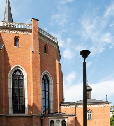 Zdjęcie nr 8: Kościół z cegły i kamienia. Na rzucie krzyża łacińskiego, jednonawowy z wciągniętymi do wnętrza przyporami. Prezbiterium krótkie, zamknięte pięcioma bokami ośmioboku. Korpus jednonawowy, czteroprzęsłowy, po bokach z płytkimi wnękami-kaplicami pomiędzy przyporami, poprzedzony od zach. przedsionkiem. Do pierwszego przęsła dostawione dwie symetryczne, trójboczne kaplice, nad nimi dwie czworoboczne wieże. Zakrystia przy prezbiterium na osi kościoła. Artykulacja ścian wnętrza za pomocą filarów opiętych półkolumnami z kapitelami z motywów liści. Między filarami rozpięte ostrołukowe arkady tworzące płytkie wnęki. Pierwsze przęsło wyróżnione przy pomocy masywnych filarów, ujętych niemal pełnoplastycznymi kolumnami. Okna ostrołukowe, dwudzielne z maswerkami, wsparte na gzymsach. Sklepienia krzyżowo-żebrowe na zaostrzonych gurtach. Kaplice artykułowane analogicznie do nawy kościoła, ze sklepieniami gwiaździstymi. Przedsionek otwiera się do kościoła trzema portalami ostrołukowymi opiętymi kolumnami. W polach archiwolt płaskorzeźby: Boże Narodzenie, Ukrzyżowanie, Wniebowstąpienie (K. Ceptowski).  W prezbiterium, na osi kościoła prostokątny otwór drzwiowy prowadzący do zakrystii. Chór muzyczny umieszczony nad kruchtą kościoła, na rzucie prostokąta, z kamienną balustradą maswerkową. Fasada kamienna, trójosiowa, zamknięta trójkątnie, flankowana lizenami przechodzącymi w ażurowe wieżyczki-latarnie, na rzucie kwadratu. Wieżyczki zwieńczone gzymsem i balustradą arkadową, hełmy ostrosłupowy zakończony iglicą. W dolnej części trzy filarowe arkady ostrołukowe, otwierające się do kruchty, sklepienie kruchty krzyżowo-żebrowe. Nad arkadami wejściowymi trzy tonda: litery IHS, Oko Opatrzności i splecione litery imienia Maria. Pośrodku na osi kościoła duża rozeta z maswerkiem, profilowana, otoczona pierścieniem wypełnionym stylizowanym ornamentem roślinnym. Ponad arkadami pełnoplastyczne figury czterech ewangelistów ustawionych na konsolach z rzeźbionymi atrybutami (F. Kuhn). Po bokach rozety prostokątne płyciny z traczami herbowymi Potockich i Branickich. U góry, na osi fasady figura Archanioła Michała. Elewacje na kamiennym cokole, z gzymsem kapnikowym, opięte prostokątnymi przyporami zwieńczonymi kamiennymi nakrywami. W górnej części kamienny fryz arkadkowy. Nad nim gzyms koronujący podtrzymujący ażurową, arkadową balustradę. Przy prezbiterium kaplice zamknięte trójbocznie, prezbiterium zamknięte pięciobocznie. Zakrystia na osi prezbiterium, na rzucie prostokąta, zwieńczona sygnaturką i ceglanym kominem. Po bokach prostokątne aneksy, południowy aneks - trzy okna ostrołukowe w kamiennej opasce, w środkowym przedstawienie Ukrzyżowanego Chrystusa. W północnym aneksie pojedyncze analogiczne okno. Okna ostrołukowe w profilowanych kamiennych opaskach, pomiędzy nimi a gzymsem koronującym mniejsze ostrołukowe w uskokowych arkadach. Nad kaplicami bocznymi dwie symetryczne wieże na rzucie kwadratu, w połowie wysokości kamienny gzyms z fryzem arkadkowym. Okna ostrołukowe w kamiennej opasce. Całość zwieńczona ślepym fryzem arkadkowym, wyżej gzyms dźwigający ażurową arkadkową balustradę. Hełmy ostrosłupowe, miedziane. Zakrystia na rzucie prostokąta, nakryta sklepieniem kolebkowym zaostrzonym i krzyżowym z lunetami , oddzielone gurtem. Portale od wschodu i zachodu prostokątne zamknięte łukiem ostrym. Okna ostrołukowe.