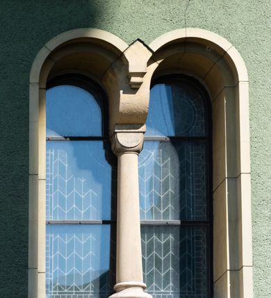 Zdjęcie nr 15: Budynki kościoła i plebanii znajdują się w centralnej części wsi, przy rynku na północ od głównej drogi z Krakowa do Oświęcimia. Kościół stoi przy obszernym placu, obwiedziony wysokim kamiennym murem z metalowym ogrodzeniem od południa. Kościół z prezbiterium zwróconym na północ, wzniesiony z kamienia wapiennego i cegły, tynkowany, z podmurówką. Świątynia wybudowana na planie krzyża łacińskiego z bazylikowym korpusem i transeptem. Dwuprzęsłowe prezbiterium zakończone półkoliście absydą zostało ujęte w dwa aneksy boczne, z których zachodni przeznaczony jest na zakrystię. Od południa do budynku przylega kruchta w przyziemiu wieży. Wnętrze kościoła trójnawowe, czteroprzęsłowe. Nawa główna łączy się z nawami bocznymi arkadami wspartymi na pięciobocznych filarach. Nawy boczne ujęte szerokimi pilastrami z pięciobocznymi filarami. Filary i pilastry stoją na wysokich, masywnych cokołach z kapitelami analogicznymi jak w nawie głównej. Ściany na skrzyżowaniu naw oraz ściany prezbiterium ujęte wspomnianymi filarami podtrzymującymi gurty sklepienia. Nawa i prezbiterium przykryte są sklepieniem kolebkowym z geometryzowanymi lunetami po obu stronach ścian. Ramiona transeptu sklepione kolebkowo z analogicznymi lunetami. Na skrzyżowaniu naw znajduje się sklepienie żaglaste. Nawę główną oświetlają rozmieszczone po jednym w każdym przęśle otwory okienne zamknięte łukiem półkolistym, okna w transepcie to biforia, widoczne tylko z zewnątrz okrągłe okno w absydzie wypełnione jest kamienną rozetą. Główne wejście od południa, do pierwszego przęsła od transeptu prowadzi dwoje drzwi w otworach o zamknięciu w kształcie łuku odciętego. W części zachodniej chór muzyczny wsparty na dwóch kolumnach i dwóch filarach dostawionych do ściany. Ich kapitele są analogiczne do pozostałych w kościele. Sklepienia dekorowane polichromią z rozetami i pękami lilii, a na skrzyżowaniu naw umieszczono malunek naścienny ukazujący Chrystusa tronującego z Bogiem Ojcem i gołębicą Ducha Świętego, a wokół nich cztery symbole ewangelistów. W fasadzie świątyni znajduje się strzelista wieża dwukondygnacyjna na planie czworokąta, przechodząca wyżej w ośmioboczną. Po bokach wieży wysokie aneksy zwieńczone schodkowo. Nad wejściem do kościoła znajduje się ozdobne okno zamknięte półkoliście i wypełnione czterema małymi rozetami ułożonymi jedna nad drugą. W kolejnej kondygnacji wieżę przepruwa biforium poniżej tarczy zegara i dekoracji arkadkowej. Wieża pełni jednocześnie funkcję dzwonnicy. Druga wieża na skrzyżowaniu nawy głównej i transeptu mieści sygnaturkę. Korpus kościoła nakryty dachem dwuspadowym, wieża wielobocznym. Wszystkie dachy kryte blachą.