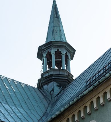 Zdjęcie nr 7: Budynki kościoła i plebanii znajdują się w centralnej części wsi, przy rynku na północ od głównej drogi z Krakowa do Oświęcimia. Kościół stoi przy obszernym placu, obwiedziony wysokim kamiennym murem z metalowym ogrodzeniem od południa. Kościół z prezbiterium zwróconym na północ, wzniesiony z kamienia wapiennego i cegły, tynkowany, z podmurówką. Świątynia wybudowana na planie krzyża łacińskiego z bazylikowym korpusem i transeptem. Dwuprzęsłowe prezbiterium zakończone półkoliście absydą zostało ujęte w dwa aneksy boczne, z których zachodni przeznaczony jest na zakrystię. Od południa do budynku przylega kruchta w przyziemiu wieży. Wnętrze kościoła trójnawowe, czteroprzęsłowe. Nawa główna łączy się z nawami bocznymi arkadami wspartymi na pięciobocznych filarach. Nawy boczne ujęte szerokimi pilastrami z pięciobocznymi filarami. Filary i pilastry stoją na wysokich, masywnych cokołach z kapitelami analogicznymi jak w nawie głównej. Ściany na skrzyżowaniu naw oraz ściany prezbiterium ujęte wspomnianymi filarami podtrzymującymi gurty sklepienia. Nawa i prezbiterium przykryte są sklepieniem kolebkowym z geometryzowanymi lunetami po obu stronach ścian. Ramiona transeptu sklepione kolebkowo z analogicznymi lunetami. Na skrzyżowaniu naw znajduje się sklepienie żaglaste. Nawę główną oświetlają rozmieszczone po jednym w każdym przęśle otwory okienne zamknięte łukiem półkolistym, okna w transepcie to biforia, widoczne tylko z zewnątrz okrągłe okno w absydzie wypełnione jest kamienną rozetą. Główne wejście od południa, do pierwszego przęsła od transeptu prowadzi dwoje drzwi w otworach o zamknięciu w kształcie łuku odciętego. W części zachodniej chór muzyczny wsparty na dwóch kolumnach i dwóch filarach dostawionych do ściany. Ich kapitele są analogiczne do pozostałych w kościele. Sklepienia dekorowane polichromią z rozetami i pękami lilii, a na skrzyżowaniu naw umieszczono malunek naścienny ukazujący Chrystusa tronującego z Bogiem Ojcem i gołębicą Ducha Świętego, a wokół nich cztery symbole ewangelistów. W fasadzie świątyni znajduje się strzelista wieża dwukondygnacyjna na planie czworokąta, przechodząca wyżej w ośmioboczną. Po bokach wieży wysokie aneksy zwieńczone schodkowo. Nad wejściem do kościoła znajduje się ozdobne okno zamknięte półkoliście i wypełnione czterema małymi rozetami ułożonymi jedna nad drugą. W kolejnej kondygnacji wieżę przepruwa biforium poniżej tarczy zegara i dekoracji arkadkowej. Wieża pełni jednocześnie funkcję dzwonnicy. Druga wieża na skrzyżowaniu nawy głównej i transeptu mieści sygnaturkę. Korpus kościoła nakryty dachem dwuspadowym, wieża wielobocznym. Wszystkie dachy kryte blachą.