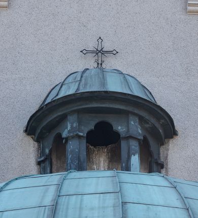 Zdjęcie nr 27: Budynki kościoła i plebanii znajdują się w centralnej części wsi, przy rynku na północ od głównej drogi z Krakowa do Oświęcimia. Kościół stoi przy obszernym placu, obwiedziony wysokim kamiennym murem z metalowym ogrodzeniem od południa. Kościół z prezbiterium zwróconym na północ, wzniesiony z kamienia wapiennego i cegły, tynkowany, z podmurówką. Świątynia wybudowana na planie krzyża łacińskiego z bazylikowym korpusem i transeptem. Dwuprzęsłowe prezbiterium zakończone półkoliście absydą zostało ujęte w dwa aneksy boczne, z których zachodni przeznaczony jest na zakrystię. Od południa do budynku przylega kruchta w przyziemiu wieży. Wnętrze kościoła trójnawowe, czteroprzęsłowe. Nawa główna łączy się z nawami bocznymi arkadami wspartymi na pięciobocznych filarach. Nawy boczne ujęte szerokimi pilastrami z pięciobocznymi filarami. Filary i pilastry stoją na wysokich, masywnych cokołach z kapitelami analogicznymi jak w nawie głównej. Ściany na skrzyżowaniu naw oraz ściany prezbiterium ujęte wspomnianymi filarami podtrzymującymi gurty sklepienia. Nawa i prezbiterium przykryte są sklepieniem kolebkowym z geometryzowanymi lunetami po obu stronach ścian. Ramiona transeptu sklepione kolebkowo z analogicznymi lunetami. Na skrzyżowaniu naw znajduje się sklepienie żaglaste. Nawę główną oświetlają rozmieszczone po jednym w każdym przęśle otwory okienne zamknięte łukiem półkolistym, okna w transepcie to biforia, widoczne tylko z zewnątrz okrągłe okno w absydzie wypełnione jest kamienną rozetą. Główne wejście od południa, do pierwszego przęsła od transeptu prowadzi dwoje drzwi w otworach o zamknięciu w kształcie łuku odciętego. W części zachodniej chór muzyczny wsparty na dwóch kolumnach i dwóch filarach dostawionych do ściany. Ich kapitele są analogiczne do pozostałych w kościele. Sklepienia dekorowane polichromią z rozetami i pękami lilii, a na skrzyżowaniu naw umieszczono malunek naścienny ukazujący Chrystusa tronującego z Bogiem Ojcem i gołębicą Ducha Świętego, a wokół nich cztery symbole ewangelistów. W fasadzie świątyni znajduje się strzelista wieża dwukondygnacyjna na planie czworokąta, przechodząca wyżej w ośmioboczną. Po bokach wieży wysokie aneksy zwieńczone schodkowo. Nad wejściem do kościoła znajduje się ozdobne okno zamknięte półkoliście i wypełnione czterema małymi rozetami ułożonymi jedna nad drugą. W kolejnej kondygnacji wieżę przepruwa biforium poniżej tarczy zegara i dekoracji arkadkowej. Wieża pełni jednocześnie funkcję dzwonnicy. Druga wieża na skrzyżowaniu nawy głównej i transeptu mieści sygnaturkę. Korpus kościoła nakryty dachem dwuspadowym, wieża wielobocznym. Wszystkie dachy kryte blachą.