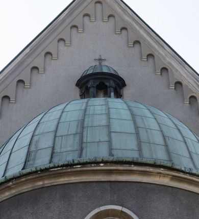 Zdjęcie nr 23: Budynki kościoła i plebanii znajdują się w centralnej części wsi, przy rynku na północ od głównej drogi z Krakowa do Oświęcimia. Kościół stoi przy obszernym placu, obwiedziony wysokim kamiennym murem z metalowym ogrodzeniem od południa. Kościół z prezbiterium zwróconym na północ, wzniesiony z kamienia wapiennego i cegły, tynkowany, z podmurówką. Świątynia wybudowana na planie krzyża łacińskiego z bazylikowym korpusem i transeptem. Dwuprzęsłowe prezbiterium zakończone półkoliście absydą zostało ujęte w dwa aneksy boczne, z których zachodni przeznaczony jest na zakrystię. Od południa do budynku przylega kruchta w przyziemiu wieży. Wnętrze kościoła trójnawowe, czteroprzęsłowe. Nawa główna łączy się z nawami bocznymi arkadami wspartymi na pięciobocznych filarach. Nawy boczne ujęte szerokimi pilastrami z pięciobocznymi filarami. Filary i pilastry stoją na wysokich, masywnych cokołach z kapitelami analogicznymi jak w nawie głównej. Ściany na skrzyżowaniu naw oraz ściany prezbiterium ujęte wspomnianymi filarami podtrzymującymi gurty sklepienia. Nawa i prezbiterium przykryte są sklepieniem kolebkowym z geometryzowanymi lunetami po obu stronach ścian. Ramiona transeptu sklepione kolebkowo z analogicznymi lunetami. Na skrzyżowaniu naw znajduje się sklepienie żaglaste. Nawę główną oświetlają rozmieszczone po jednym w każdym przęśle otwory okienne zamknięte łukiem półkolistym, okna w transepcie to biforia, widoczne tylko z zewnątrz okrągłe okno w absydzie wypełnione jest kamienną rozetą. Główne wejście od południa, do pierwszego przęsła od transeptu prowadzi dwoje drzwi w otworach o zamknięciu w kształcie łuku odciętego. W części zachodniej chór muzyczny wsparty na dwóch kolumnach i dwóch filarach dostawionych do ściany. Ich kapitele są analogiczne do pozostałych w kościele. Sklepienia dekorowane polichromią z rozetami i pękami lilii, a na skrzyżowaniu naw umieszczono malunek naścienny ukazujący Chrystusa tronującego z Bogiem Ojcem i gołębicą Ducha Świętego, a wokół nich cztery symbole ewangelistów. W fasadzie świątyni znajduje się strzelista wieża dwukondygnacyjna na planie czworokąta, przechodząca wyżej w ośmioboczną. Po bokach wieży wysokie aneksy zwieńczone schodkowo. Nad wejściem do kościoła znajduje się ozdobne okno zamknięte półkoliście i wypełnione czterema małymi rozetami ułożonymi jedna nad drugą. W kolejnej kondygnacji wieżę przepruwa biforium poniżej tarczy zegara i dekoracji arkadkowej. Wieża pełni jednocześnie funkcję dzwonnicy. Druga wieża na skrzyżowaniu nawy głównej i transeptu mieści sygnaturkę. Korpus kościoła nakryty dachem dwuspadowym, wieża wielobocznym. Wszystkie dachy kryte blachą.