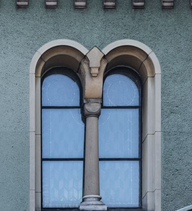 Zdjęcie nr 14: Budynki kościoła i plebanii znajdują się w centralnej części wsi, przy rynku na północ od głównej drogi z Krakowa do Oświęcimia. Kościół stoi przy obszernym placu, obwiedziony wysokim kamiennym murem z metalowym ogrodzeniem od południa. Kościół z prezbiterium zwróconym na północ, wzniesiony z kamienia wapiennego i cegły, tynkowany, z podmurówką. Świątynia wybudowana na planie krzyża łacińskiego z bazylikowym korpusem i transeptem. Dwuprzęsłowe prezbiterium zakończone półkoliście absydą zostało ujęte w dwa aneksy boczne, z których zachodni przeznaczony jest na zakrystię. Od południa do budynku przylega kruchta w przyziemiu wieży. Wnętrze kościoła trójnawowe, czteroprzęsłowe. Nawa główna łączy się z nawami bocznymi arkadami wspartymi na pięciobocznych filarach. Nawy boczne ujęte szerokimi pilastrami z pięciobocznymi filarami. Filary i pilastry stoją na wysokich, masywnych cokołach z kapitelami analogicznymi jak w nawie głównej. Ściany na skrzyżowaniu naw oraz ściany prezbiterium ujęte wspomnianymi filarami podtrzymującymi gurty sklepienia. Nawa i prezbiterium przykryte są sklepieniem kolebkowym z geometryzowanymi lunetami po obu stronach ścian. Ramiona transeptu sklepione kolebkowo z analogicznymi lunetami. Na skrzyżowaniu naw znajduje się sklepienie żaglaste. Nawę główną oświetlają rozmieszczone po jednym w każdym przęśle otwory okienne zamknięte łukiem półkolistym, okna w transepcie to biforia, widoczne tylko z zewnątrz okrągłe okno w absydzie wypełnione jest kamienną rozetą. Główne wejście od południa, do pierwszego przęsła od transeptu prowadzi dwoje drzwi w otworach o zamknięciu w kształcie łuku odciętego. W części zachodniej chór muzyczny wsparty na dwóch kolumnach i dwóch filarach dostawionych do ściany. Ich kapitele są analogiczne do pozostałych w kościele. Sklepienia dekorowane polichromią z rozetami i pękami lilii, a na skrzyżowaniu naw umieszczono malunek naścienny ukazujący Chrystusa tronującego z Bogiem Ojcem i gołębicą Ducha Świętego, a wokół nich cztery symbole ewangelistów. W fasadzie świątyni znajduje się strzelista wieża dwukondygnacyjna na planie czworokąta, przechodząca wyżej w ośmioboczną. Po bokach wieży wysokie aneksy zwieńczone schodkowo. Nad wejściem do kościoła znajduje się ozdobne okno zamknięte półkoliście i wypełnione czterema małymi rozetami ułożonymi jedna nad drugą. W kolejnej kondygnacji wieżę przepruwa biforium poniżej tarczy zegara i dekoracji arkadkowej. Wieża pełni jednocześnie funkcję dzwonnicy. Druga wieża na skrzyżowaniu nawy głównej i transeptu mieści sygnaturkę. Korpus kościoła nakryty dachem dwuspadowym, wieża wielobocznym. Wszystkie dachy kryte blachą.