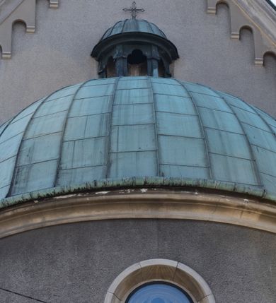 Zdjęcie nr 25: Budynki kościoła i plebanii znajdują się w centralnej części wsi, przy rynku na północ od głównej drogi z Krakowa do Oświęcimia. Kościół stoi przy obszernym placu, obwiedziony wysokim kamiennym murem z metalowym ogrodzeniem od południa. Kościół z prezbiterium zwróconym na północ, wzniesiony z kamienia wapiennego i cegły, tynkowany, z podmurówką. Świątynia wybudowana na planie krzyża łacińskiego z bazylikowym korpusem i transeptem. Dwuprzęsłowe prezbiterium zakończone półkoliście absydą zostało ujęte w dwa aneksy boczne, z których zachodni przeznaczony jest na zakrystię. Od południa do budynku przylega kruchta w przyziemiu wieży. Wnętrze kościoła trójnawowe, czteroprzęsłowe. Nawa główna łączy się z nawami bocznymi arkadami wspartymi na pięciobocznych filarach. Nawy boczne ujęte szerokimi pilastrami z pięciobocznymi filarami. Filary i pilastry stoją na wysokich, masywnych cokołach z kapitelami analogicznymi jak w nawie głównej. Ściany na skrzyżowaniu naw oraz ściany prezbiterium ujęte wspomnianymi filarami podtrzymującymi gurty sklepienia. Nawa i prezbiterium przykryte są sklepieniem kolebkowym z geometryzowanymi lunetami po obu stronach ścian. Ramiona transeptu sklepione kolebkowo z analogicznymi lunetami. Na skrzyżowaniu naw znajduje się sklepienie żaglaste. Nawę główną oświetlają rozmieszczone po jednym w każdym przęśle otwory okienne zamknięte łukiem półkolistym, okna w transepcie to biforia, widoczne tylko z zewnątrz okrągłe okno w absydzie wypełnione jest kamienną rozetą. Główne wejście od południa, do pierwszego przęsła od transeptu prowadzi dwoje drzwi w otworach o zamknięciu w kształcie łuku odciętego. W części zachodniej chór muzyczny wsparty na dwóch kolumnach i dwóch filarach dostawionych do ściany. Ich kapitele są analogiczne do pozostałych w kościele. Sklepienia dekorowane polichromią z rozetami i pękami lilii, a na skrzyżowaniu naw umieszczono malunek naścienny ukazujący Chrystusa tronującego z Bogiem Ojcem i gołębicą Ducha Świętego, a wokół nich cztery symbole ewangelistów. W fasadzie świątyni znajduje się strzelista wieża dwukondygnacyjna na planie czworokąta, przechodząca wyżej w ośmioboczną. Po bokach wieży wysokie aneksy zwieńczone schodkowo. Nad wejściem do kościoła znajduje się ozdobne okno zamknięte półkoliście i wypełnione czterema małymi rozetami ułożonymi jedna nad drugą. W kolejnej kondygnacji wieżę przepruwa biforium poniżej tarczy zegara i dekoracji arkadkowej. Wieża pełni jednocześnie funkcję dzwonnicy. Druga wieża na skrzyżowaniu nawy głównej i transeptu mieści sygnaturkę. Korpus kościoła nakryty dachem dwuspadowym, wieża wielobocznym. Wszystkie dachy kryte blachą.