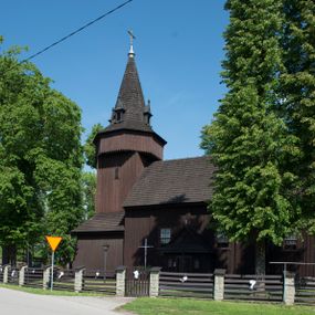 Zdjęcie nr 1: Kościół św. Jakuba w Palczowicach został wybudowany w roku 1894 w miejsce wcześniejszego kościoła z roku 1498. Kościół halowy, na kamiennej podmurówce, wzniesiony z drewna.  Kościół jest jednonawowy, orientowany.  Po jego zachodniej stronie szeroka, czworoboczna wieża nakryta ośmiobocznym hełmem. Pod hełmem również ośmioboczny szeroki, drewniany kandelabr. Hełm strzelisty, kryty gontem, zwieńczony metalowym krzyżem. Z czterech stron hełmu metalowe wykusze okienne  ze stylizowanymi sterczynami. Po czterech stronach korpusu wieży w jego wysokości małe otwory okienne  zwieńczone ostrokątnie. Korpus halowy nakryty dwuspadowym dachem z gontu.  We wschodniej części dachu ośmioboczna metalowa sygnaturka również zwieńczona krzyżem. Jej hełm strzelisty z pokryciem metalowym. W korpusie od południa i północy po dwa prostokątne otwory okienne z bliźniaczymi zamkniętymi ostrołukowo kwaterami. Prezbiterium niższe i węższe w stosunku do nawy, kryte osobnym, dwuspadowym dachem gontowym, zamknięte trójbocznie. Po południowej stronie prezbiterium dwa otwory okienne analogiczne do zlokalizowanych w nawie. Po północnej stronie prezbiterium dobudowana murowana, tynkowana zakrystia z dachem jednospadowym, krytym blachą.  W zakrystii jeden czworokątny otwór okienny i osobne wejście po stronie wschodniej. Nad głównym wejściem do kościoła, z czworobocznymi, dwuskrzydłowymi drzwiami  wysunięte dwuspadowe zadaszenie Po bokach drzwi w połowie ich wysokości symetrycznie ułożone, czworokątne otwory okienne. Do południowej ściany nawy głównej przylegająca drewniana kruchta na planie prostokątnym z dwuspadowym zadaszeniem zwieńczonym krzyżem. Po obu stronach drzwi otwory okienne zwieńczone ostrokątnie.