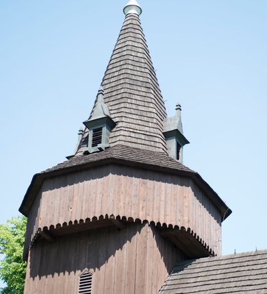 Zdjęcie nr 8: Kościół św. Jakuba w Palczowicach został wybudowany w roku 1894 w miejsce wcześniejszego kościoła z roku 1498. Kościół halowy, na kamiennej podmurówce, wzniesiony z drewna.  Kościół jest jednonawowy, orientowany.  Po jego zachodniej stronie szeroka, czworoboczna wieża nakryta ośmiobocznym hełmem. Pod hełmem również ośmioboczny szeroki, drewniany kandelabr. Hełm strzelisty, kryty gontem, zwieńczony metalowym krzyżem. Z czterech stron hełmu metalowe wykusze okienne  ze stylizowanymi sterczynami. Po czterech stronach korpusu wieży w jego wysokości małe otwory okienne  zwieńczone ostrokątnie. Korpus halowy nakryty dwuspadowym dachem z gontu.  We wschodniej części dachu ośmioboczna metalowa sygnaturka również zwieńczona krzyżem. Jej hełm strzelisty z pokryciem metalowym. W korpusie od południa i północy po dwa prostokątne otwory okienne z bliźniaczymi zamkniętymi ostrołukowo kwaterami. Prezbiterium niższe i węższe w stosunku do nawy, kryte osobnym, dwuspadowym dachem gontowym, zamknięte trójbocznie. Po południowej stronie prezbiterium dwa otwory okienne analogiczne do zlokalizowanych w nawie. Po północnej stronie prezbiterium dobudowana murowana, tynkowana zakrystia z dachem jednospadowym, krytym blachą.  W zakrystii jeden czworokątny otwór okienny i osobne wejście po stronie wschodniej. Nad głównym wejściem do kościoła, z czworobocznymi, dwuskrzydłowymi drzwiami  wysunięte dwuspadowe zadaszenie Po bokach drzwi w połowie ich wysokości symetrycznie ułożone, czworokątne otwory okienne. Do południowej ściany nawy głównej przylegająca drewniana kruchta na planie prostokątnym z dwuspadowym zadaszeniem zwieńczonym krzyżem. Po obu stronach drzwi otwory okienne zwieńczone ostrokątnie.