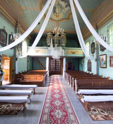 Zdjęcie nr 16: Kościół św. Jakuba w Palczowicach został wybudowany w roku 1894 w miejsce wcześniejszego kościoła z roku 1498. Kościół halowy, na kamiennej podmurówce, wzniesiony z drewna.  Kościół jest jednonawowy, orientowany.  Po jego zachodniej stronie szeroka, czworoboczna wieża nakryta ośmiobocznym hełmem. Pod hełmem również ośmioboczny szeroki, drewniany kandelabr. Hełm strzelisty, kryty gontem, zwieńczony metalowym krzyżem. Z czterech stron hełmu metalowe wykusze okienne  ze stylizowanymi sterczynami. Po czterech stronach korpusu wieży w jego wysokości małe otwory okienne  zwieńczone ostrokątnie. Korpus halowy nakryty dwuspadowym dachem z gontu.  We wschodniej części dachu ośmioboczna metalowa sygnaturka również zwieńczona krzyżem. Jej hełm strzelisty z pokryciem metalowym. W korpusie od południa i północy po dwa prostokątne otwory okienne z bliźniaczymi zamkniętymi ostrołukowo kwaterami. Prezbiterium niższe i węższe w stosunku do nawy, kryte osobnym, dwuspadowym dachem gontowym, zamknięte trójbocznie. Po południowej stronie prezbiterium dwa otwory okienne analogiczne do zlokalizowanych w nawie. Po północnej stronie prezbiterium dobudowana murowana, tynkowana zakrystia z dachem jednospadowym, krytym blachą.  W zakrystii jeden czworokątny otwór okienny i osobne wejście po stronie wschodniej. Nad głównym wejściem do kościoła, z czworobocznymi, dwuskrzydłowymi drzwiami  wysunięte dwuspadowe zadaszenie Po bokach drzwi w połowie ich wysokości symetrycznie ułożone, czworokątne otwory okienne. Do południowej ściany nawy głównej przylegająca drewniana kruchta na planie prostokątnym z dwuspadowym zadaszeniem zwieńczonym krzyżem. Po obu stronach drzwi otwory okienne zwieńczone ostrokątnie.