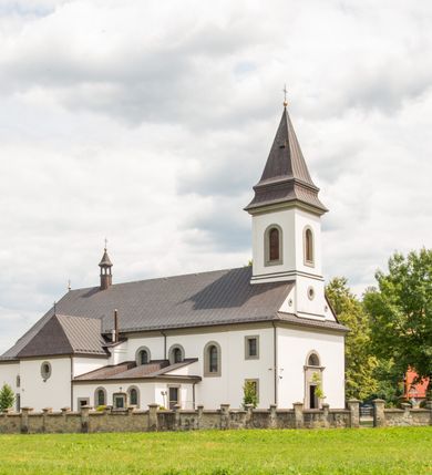 Zdjęcie nr 3: Kościół murowany, tynkowany, orientowany, jednonawowy. Prezbiterium prostokątne, krótkie, zamknięte trójbocznie, przy północnej ścianie prostokątna zakrystia z niższym przedsionkiem. Od wschodu, na zewnętrznej ścianie prezbiterium ogrójec. Nawa główna szersza od prezbiterium, na rzucie prostokąta, od północy przylega prostokątna kaplica, do której od zachodu dobudowany jest niski przedsionek, od południa przylega kruchta boczna, od zachodu prostokątny przedsionek z wieżą na planie kwadratu. Prezbiterium i nawa nakryte stropami, łuk tęczowy półkolisty, wewnątrz ujęty pilastrami, zakończony kluczem. Dostęp do kaplicy z nawy głównej przez wysokie przejście arkadowe na ścianie północnej, w południowej przejście do kruchty bocznej, na osi, pod chórem wejście do przedsionka. Kaplica boczna sklepiona kolebkowo. Fasada bez podziałów z wbudowaną wieżą, ujętą spłaszczonymi spływami. Na osi portal wejściowy flankowany dwoma pilastrami podtrzymującymi gzyms, na którym znajduje się półkoliste okno. W polu dwuskrzydłowe drzwi wejściowe ujęte opaską tynkową. Wieża dwukondygnacyjna, w dolnej kondygnacji okulus, w górnej okna w formie stojącego prostokąta zamkniętego łukiem półkolistym usytuowane z czterech stron. Na spływach ujmujących wieżę dwa okulusy. Wieża nakryta dachem ostrosłupowym. Południowa ściana oraz prezbiterium opięte grubymi szkarpami nakrytymi daszkami o nieregularnej wysokości. Do wschodniej ściany prezbiterium dobudowany murowany ogrojec flankowany filarami, nakryty wielospadowym daszkiem. Elewacje gładkie, tynkowane zakończone profilowanym gzymsem. Wejścia do kościoła przez przybudówkę kaplicy bocznej od północy oraz przez zachodni przedsionek i południową kruchtę. Okna w formie stojącego prostokąta zamkniętego łukiem półkolistym: siedem w elewacji południowej, trzy w północnej. Okna w formie stojącego prostokąta w dwóch kondygnacjach na północnej i południowej ścianie przedsionka zachodniego. Nawa główna, prezbiterium, kaplica i kruchta boczna nakryte dachem dwuspadowym, zakrystia i przybudówki dachami pulpitowymi. 
