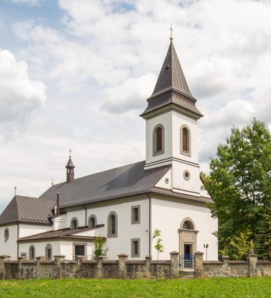 Zdjęcie nr 5: Kościół murowany, tynkowany, orientowany, jednonawowy. Prezbiterium prostokątne, krótkie, zamknięte trójbocznie, przy północnej ścianie prostokątna zakrystia z niższym przedsionkiem. Od wschodu, na zewnętrznej ścianie prezbiterium ogrójec. Nawa główna szersza od prezbiterium, na rzucie prostokąta, od północy przylega prostokątna kaplica, do której od zachodu dobudowany jest niski przedsionek, od południa przylega kruchta boczna, od zachodu prostokątny przedsionek z wieżą na planie kwadratu. Prezbiterium i nawa nakryte stropami, łuk tęczowy półkolisty, wewnątrz ujęty pilastrami, zakończony kluczem. Dostęp do kaplicy z nawy głównej przez wysokie przejście arkadowe na ścianie północnej, w południowej przejście do kruchty bocznej, na osi, pod chórem wejście do przedsionka. Kaplica boczna sklepiona kolebkowo. Fasada bez podziałów z wbudowaną wieżą, ujętą spłaszczonymi spływami. Na osi portal wejściowy flankowany dwoma pilastrami podtrzymującymi gzyms, na którym znajduje się półkoliste okno. W polu dwuskrzydłowe drzwi wejściowe ujęte opaską tynkową. Wieża dwukondygnacyjna, w dolnej kondygnacji okulus, w górnej okna w formie stojącego prostokąta zamkniętego łukiem półkolistym usytuowane z czterech stron. Na spływach ujmujących wieżę dwa okulusy. Wieża nakryta dachem ostrosłupowym. Południowa ściana oraz prezbiterium opięte grubymi szkarpami nakrytymi daszkami o nieregularnej wysokości. Do wschodniej ściany prezbiterium dobudowany murowany ogrojec flankowany filarami, nakryty wielospadowym daszkiem. Elewacje gładkie, tynkowane zakończone profilowanym gzymsem. Wejścia do kościoła przez przybudówkę kaplicy bocznej od północy oraz przez zachodni przedsionek i południową kruchtę. Okna w formie stojącego prostokąta zamkniętego łukiem półkolistym: siedem w elewacji południowej, trzy w północnej. Okna w formie stojącego prostokąta w dwóch kondygnacjach na północnej i południowej ścianie przedsionka zachodniego. Nawa główna, prezbiterium, kaplica i kruchta boczna nakryte dachem dwuspadowym, zakrystia i przybudówki dachami pulpitowymi. 
