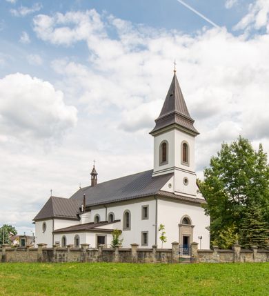 Zdjęcie nr 2: Kościół murowany, tynkowany, orientowany, jednonawowy. Prezbiterium prostokątne, krótkie, zamknięte trójbocznie, przy północnej ścianie prostokątna zakrystia z niższym przedsionkiem. Od wschodu, na zewnętrznej ścianie prezbiterium ogrójec. Nawa główna szersza od prezbiterium, na rzucie prostokąta, od północy przylega prostokątna kaplica, do której od zachodu dobudowany jest niski przedsionek, od południa przylega kruchta boczna, od zachodu prostokątny przedsionek z wieżą na planie kwadratu. Prezbiterium i nawa nakryte stropami, łuk tęczowy półkolisty, wewnątrz ujęty pilastrami, zakończony kluczem. Dostęp do kaplicy z nawy głównej przez wysokie przejście arkadowe na ścianie północnej, w południowej przejście do kruchty bocznej, na osi, pod chórem wejście do przedsionka. Kaplica boczna sklepiona kolebkowo. Fasada bez podziałów z wbudowaną wieżą, ujętą spłaszczonymi spływami. Na osi portal wejściowy flankowany dwoma pilastrami podtrzymującymi gzyms, na którym znajduje się półkoliste okno. W polu dwuskrzydłowe drzwi wejściowe ujęte opaską tynkową. Wieża dwukondygnacyjna, w dolnej kondygnacji okulus, w górnej okna w formie stojącego prostokąta zamkniętego łukiem półkolistym usytuowane z czterech stron. Na spływach ujmujących wieżę dwa okulusy. Wieża nakryta dachem ostrosłupowym. Południowa ściana oraz prezbiterium opięte grubymi szkarpami nakrytymi daszkami o nieregularnej wysokości. Do wschodniej ściany prezbiterium dobudowany murowany ogrojec flankowany filarami, nakryty wielospadowym daszkiem. Elewacje gładkie, tynkowane zakończone profilowanym gzymsem. Wejścia do kościoła przez przybudówkę kaplicy bocznej od północy oraz przez zachodni przedsionek i południową kruchtę. Okna w formie stojącego prostokąta zamkniętego łukiem półkolistym: siedem w elewacji południowej, trzy w północnej. Okna w formie stojącego prostokąta w dwóch kondygnacjach na północnej i południowej ścianie przedsionka zachodniego. Nawa główna, prezbiterium, kaplica i kruchta boczna nakryte dachem dwuspadowym, zakrystia i przybudówki dachami pulpitowymi. 
