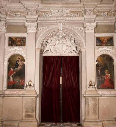 Zdjęcie nr 129: Kaplica zbudowana została na planie kwadratu i nakryta wzniesioną na pendentywach kopułą z latarnią. Przylega do kościoła od północy, do pierwszego przęsła nawy, z którą komunikuje się zamkniętym półkoliście przejściem. Wnętrze artykułowane jest w oparciu o schemat starożytnego łuku triumfalnego za pomocą osadzonych na wysokim cokole pilastrów z kompozytowymi głowicami. Pilastry podtrzymują wydatne belkowanie, ozodbione dekoracją stiukową w postaci puttów, festonów owocowych, rozet oraz kartuszy. Równocześnie pilastry ujmują półkoliste arkady, dwie niższe i większą, środkową. Niższe arkady wypełniają obrazy ze scenami z życia św. Karola Boromeusza. Ponad nimi w prostokątnych, stiukowych, obramieniach znajdują się malowane przedstawienia różnych świętych. W środkowej arkadzie ściany północnej umieszczono okazały późnobarokowy ołtarz z cudownym wizerunkiem św. Karola Boromeusza. Z kolei w arkadach wschodniej i zachodniej rozmieszczono prostokątne okna. Poniżej okna w arkadzie zachodniej znajduje się wyjście na zewnątrz kaplicy zaopatrzone w metalowe, prostokątne drzwi. Natomiast pod oknem w ścianie wschodniej zawieszono tablicę pamiątkową ku czci papieża Jana Pawła II. Arkadę wejściową do kaplicy zamyka prostokątna, brązowa krata. W jej podłuczu od wnętrza na wzór tympanonu umieszczono stiukowy kartusz z herbem Szreniawa, podtrzymywany przez dwa anioły. Ściany tarczowe podniebia przepruto czworobocznymi oknami ujętymi w stiukowe obramienia wolutowe. Na pendentywach przedstawiono w czterech stiukowych kartuszach herby: Szreniawa, Gryf i Kotwicz. Czwarty kartusz jest pusty. Czaszę kopuły wypełnia iluzjonistycznie malowana architektura podzielona na dwie strefy. Dolną artykułują pary pilastrów ujmujące okulusy oraz tralkowa balustrada, a górną gurty wyznaczające pola dla dekoracji ornamentalnej. Ściany zewnętrzne kaplicy zostały podzielone za pomocą kamiennych gzymsów i lizen na dwie trójosiowe kondygnacje, z których górna odpowiada wysokością smukłemu cokołowi mieszczącemu wejście. Zewnętrzne pola każdej elewacji dekorowane są płaskimi pasami tynku w układzie wzoru geometrycznego, zbliżonego do okuciowego. Okna i portal zostały ujęte w profilowane kamienne obramienia. Na ścianie północnej w środkowej kondygnacji pod kartuszem z herbem Szreniawa umieszczono tablicę fundacyjną z napisem: STANISLAUS COMES IN WIŚNICZ LUBOMIRSKI / PALATINUS ET GENERALIS CRACOVIEN[SIS] / SCEPUSIEN[SIS], BIALLOCERKIEVIEN[SIS] / ZATHORIEN[SIS], NIEPOLOMICIEN[SIS] E[T]C[ETER]A, E[T]C[ETER]A, CAPITANEUS / CAPELLAM HANC, / S[ANCTO] CAROLO BARRHOMAEO SUO TUTELARI PATRONO / POST RECEPTA SA[N]CTI HUIUS MERITIS TOT BENEFICIA / DICATAM / EX FUNDAMENTIS EREXIT, DONAVIT / EXORNAVIT, / ANNO D[O]MI[NI], 1640 (Stanisław hrabia na Wiśniczu Lubomirski wojewoda i starosta generalny krakowski, starosta spiski, białocerkiewski, zatorski, niepołomicki, i tak dalej, i tak dalej, tę kaplicę, poświęconą św. Karolowi Boromeuszowi, swojemu patronowi opiekuńczemu, po otrzymaniu tak wielkich łask za wstawiennictwem tego świetego, od fundamentów wzniósł, uposażył i ozdobił, roku Pańskiego 1640). Dach kaplicy oraz latarnia pokryte są blachą miedzianą.
