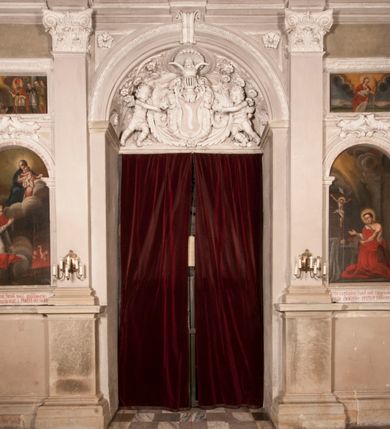 Zdjęcie nr 130: Kaplica zbudowana została na planie kwadratu i nakryta wzniesioną na pendentywach kopułą z latarnią. Przylega do kościoła od północy, do pierwszego przęsła nawy, z którą komunikuje się zamkniętym półkoliście przejściem. Wnętrze artykułowane jest w oparciu o schemat starożytnego łuku triumfalnego za pomocą osadzonych na wysokim cokole pilastrów z kompozytowymi głowicami. Pilastry podtrzymują wydatne belkowanie, ozodbione dekoracją stiukową w postaci puttów, festonów owocowych, rozet oraz kartuszy. Równocześnie pilastry ujmują półkoliste arkady, dwie niższe i większą, środkową. Niższe arkady wypełniają obrazy ze scenami z życia św. Karola Boromeusza. Ponad nimi w prostokątnych, stiukowych, obramieniach znajdują się malowane przedstawienia różnych świętych. W środkowej arkadzie ściany północnej umieszczono okazały późnobarokowy ołtarz z cudownym wizerunkiem św. Karola Boromeusza. Z kolei w arkadach wschodniej i zachodniej rozmieszczono prostokątne okna. Poniżej okna w arkadzie zachodniej znajduje się wyjście na zewnątrz kaplicy zaopatrzone w metalowe, prostokątne drzwi. Natomiast pod oknem w ścianie wschodniej zawieszono tablicę pamiątkową ku czci papieża Jana Pawła II. Arkadę wejściową do kaplicy zamyka prostokątna, brązowa krata. W jej podłuczu od wnętrza na wzór tympanonu umieszczono stiukowy kartusz z herbem Szreniawa, podtrzymywany przez dwa anioły. Ściany tarczowe podniebia przepruto czworobocznymi oknami ujętymi w stiukowe obramienia wolutowe. Na pendentywach przedstawiono w czterech stiukowych kartuszach herby: Szreniawa, Gryf i Kotwicz. Czwarty kartusz jest pusty. Czaszę kopuły wypełnia iluzjonistycznie malowana architektura podzielona na dwie strefy. Dolną artykułują pary pilastrów ujmujące okulusy oraz tralkowa balustrada, a górną gurty wyznaczające pola dla dekoracji ornamentalnej. Ściany zewnętrzne kaplicy zostały podzielone za pomocą kamiennych gzymsów i lizen na dwie trójosiowe kondygnacje, z których górna odpowiada wysokością smukłemu cokołowi mieszczącemu wejście. Zewnętrzne pola każdej elewacji dekorowane są płaskimi pasami tynku w układzie wzoru geometrycznego, zbliżonego do okuciowego. Okna i portal zostały ujęte w profilowane kamienne obramienia. Na ścianie północnej w środkowej kondygnacji pod kartuszem z herbem Szreniawa umieszczono tablicę fundacyjną z napisem: STANISLAUS COMES IN WIŚNICZ LUBOMIRSKI / PALATINUS ET GENERALIS CRACOVIEN[SIS] / SCEPUSIEN[SIS], BIALLOCERKIEVIEN[SIS] / ZATHORIEN[SIS], NIEPOLOMICIEN[SIS] E[T]C[ETER]A, E[T]C[ETER]A, CAPITANEUS / CAPELLAM HANC, / S[ANCTO] CAROLO BARRHOMAEO SUO TUTELARI PATRONO / POST RECEPTA SA[N]CTI HUIUS MERITIS TOT BENEFICIA / DICATAM / EX FUNDAMENTIS EREXIT, DONAVIT / EXORNAVIT, / ANNO D[O]MI[NI], 1640 (Stanisław hrabia na Wiśniczu Lubomirski wojewoda i starosta generalny krakowski, starosta spiski, białocerkiewski, zatorski, niepołomicki, i tak dalej, i tak dalej, tę kaplicę, poświęconą św. Karolowi Boromeuszowi, swojemu patronowi opiekuńczemu, po otrzymaniu tak wielkich łask za wstawiennictwem tego świetego, od fundamentów wzniósł, uposażył i ozdobił, roku Pańskiego 1640). Dach kaplicy oraz latarnia pokryte są blachą miedzianą.
