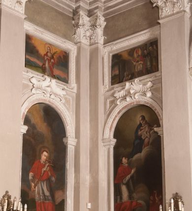 Zdjęcie nr 131: Kaplica zbudowana została na planie kwadratu i nakryta wzniesioną na pendentywach kopułą z latarnią. Przylega do kościoła od północy, do pierwszego przęsła nawy, z którą komunikuje się zamkniętym półkoliście przejściem. Wnętrze artykułowane jest w oparciu o schemat starożytnego łuku triumfalnego za pomocą osadzonych na wysokim cokole pilastrów z kompozytowymi głowicami. Pilastry podtrzymują wydatne belkowanie, ozodbione dekoracją stiukową w postaci puttów, festonów owocowych, rozet oraz kartuszy. Równocześnie pilastry ujmują półkoliste arkady, dwie niższe i większą, środkową. Niższe arkady wypełniają obrazy ze scenami z życia św. Karola Boromeusza. Ponad nimi w prostokątnych, stiukowych, obramieniach znajdują się malowane przedstawienia różnych świętych. W środkowej arkadzie ściany północnej umieszczono okazały późnobarokowy ołtarz z cudownym wizerunkiem św. Karola Boromeusza. Z kolei w arkadach wschodniej i zachodniej rozmieszczono prostokątne okna. Poniżej okna w arkadzie zachodniej znajduje się wyjście na zewnątrz kaplicy zaopatrzone w metalowe, prostokątne drzwi. Natomiast pod oknem w ścianie wschodniej zawieszono tablicę pamiątkową ku czci papieża Jana Pawła II. Arkadę wejściową do kaplicy zamyka prostokątna, brązowa krata. W jej podłuczu od wnętrza na wzór tympanonu umieszczono stiukowy kartusz z herbem Szreniawa, podtrzymywany przez dwa anioły. Ściany tarczowe podniebia przepruto czworobocznymi oknami ujętymi w stiukowe obramienia wolutowe. Na pendentywach przedstawiono w czterech stiukowych kartuszach herby: Szreniawa, Gryf i Kotwicz. Czwarty kartusz jest pusty. Czaszę kopuły wypełnia iluzjonistycznie malowana architektura podzielona na dwie strefy. Dolną artykułują pary pilastrów ujmujące okulusy oraz tralkowa balustrada, a górną gurty wyznaczające pola dla dekoracji ornamentalnej. Ściany zewnętrzne kaplicy zostały podzielone za pomocą kamiennych gzymsów i lizen na dwie trójosiowe kondygnacje, z których górna odpowiada wysokością smukłemu cokołowi mieszczącemu wejście. Zewnętrzne pola każdej elewacji dekorowane są płaskimi pasami tynku w układzie wzoru geometrycznego, zbliżonego do okuciowego. Okna i portal zostały ujęte w profilowane kamienne obramienia. Na ścianie północnej w środkowej kondygnacji pod kartuszem z herbem Szreniawa umieszczono tablicę fundacyjną z napisem: STANISLAUS COMES IN WIŚNICZ LUBOMIRSKI / PALATINUS ET GENERALIS CRACOVIEN[SIS] / SCEPUSIEN[SIS], BIALLOCERKIEVIEN[SIS] / ZATHORIEN[SIS], NIEPOLOMICIEN[SIS] E[T]C[ETER]A, E[T]C[ETER]A, CAPITANEUS / CAPELLAM HANC, / S[ANCTO] CAROLO BARRHOMAEO SUO TUTELARI PATRONO / POST RECEPTA SA[N]CTI HUIUS MERITIS TOT BENEFICIA / DICATAM / EX FUNDAMENTIS EREXIT, DONAVIT / EXORNAVIT, / ANNO D[O]MI[NI], 1640 (Stanisław hrabia na Wiśniczu Lubomirski wojewoda i starosta generalny krakowski, starosta spiski, białocerkiewski, zatorski, niepołomicki, i tak dalej, i tak dalej, tę kaplicę, poświęconą św. Karolowi Boromeuszowi, swojemu patronowi opiekuńczemu, po otrzymaniu tak wielkich łask za wstawiennictwem tego świetego, od fundamentów wzniósł, uposażył i ozdobił, roku Pańskiego 1640). Dach kaplicy oraz latarnia pokryte są blachą miedzianą.
