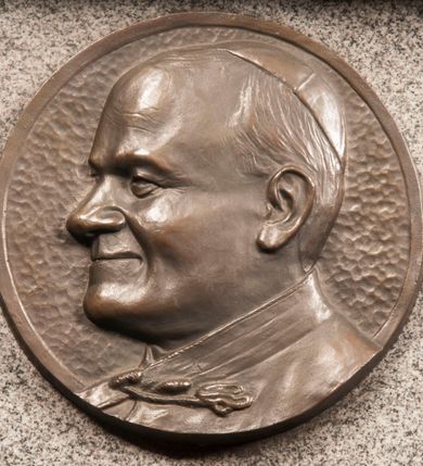 Zdjęcie nr 134: Kaplica zbudowana została na planie kwadratu i nakryta wzniesioną na pendentywach kopułą z latarnią. Przylega do kościoła od północy, do pierwszego przęsła nawy, z którą komunikuje się zamkniętym półkoliście przejściem. Wnętrze artykułowane jest w oparciu o schemat starożytnego łuku triumfalnego za pomocą osadzonych na wysokim cokole pilastrów z kompozytowymi głowicami. Pilastry podtrzymują wydatne belkowanie, ozodbione dekoracją stiukową w postaci puttów, festonów owocowych, rozet oraz kartuszy. Równocześnie pilastry ujmują półkoliste arkady, dwie niższe i większą, środkową. Niższe arkady wypełniają obrazy ze scenami z życia św. Karola Boromeusza. Ponad nimi w prostokątnych, stiukowych, obramieniach znajdują się malowane przedstawienia różnych świętych. W środkowej arkadzie ściany północnej umieszczono okazały późnobarokowy ołtarz z cudownym wizerunkiem św. Karola Boromeusza. Z kolei w arkadach wschodniej i zachodniej rozmieszczono prostokątne okna. Poniżej okna w arkadzie zachodniej znajduje się wyjście na zewnątrz kaplicy zaopatrzone w metalowe, prostokątne drzwi. Natomiast pod oknem w ścianie wschodniej zawieszono tablicę pamiątkową ku czci papieża Jana Pawła II. Arkadę wejściową do kaplicy zamyka prostokątna, brązowa krata. W jej podłuczu od wnętrza na wzór tympanonu umieszczono stiukowy kartusz z herbem Szreniawa, podtrzymywany przez dwa anioły. Ściany tarczowe podniebia przepruto czworobocznymi oknami ujętymi w stiukowe obramienia wolutowe. Na pendentywach przedstawiono w czterech stiukowych kartuszach herby: Szreniawa, Gryf i Kotwicz. Czwarty kartusz jest pusty. Czaszę kopuły wypełnia iluzjonistycznie malowana architektura podzielona na dwie strefy. Dolną artykułują pary pilastrów ujmujące okulusy oraz tralkowa balustrada, a górną gurty wyznaczające pola dla dekoracji ornamentalnej. Ściany zewnętrzne kaplicy zostały podzielone za pomocą kamiennych gzymsów i lizen na dwie trójosiowe kondygnacje, z których górna odpowiada wysokością smukłemu cokołowi mieszczącemu wejście. Zewnętrzne pola każdej elewacji dekorowane są płaskimi pasami tynku w układzie wzoru geometrycznego, zbliżonego do okuciowego. Okna i portal zostały ujęte w profilowane kamienne obramienia. Na ścianie północnej w środkowej kondygnacji pod kartuszem z herbem Szreniawa umieszczono tablicę fundacyjną z napisem: STANISLAUS COMES IN WIŚNICZ LUBOMIRSKI / PALATINUS ET GENERALIS CRACOVIEN[SIS] / SCEPUSIEN[SIS], BIALLOCERKIEVIEN[SIS] / ZATHORIEN[SIS], NIEPOLOMICIEN[SIS] E[T]C[ETER]A, E[T]C[ETER]A, CAPITANEUS / CAPELLAM HANC, / S[ANCTO] CAROLO BARRHOMAEO SUO TUTELARI PATRONO / POST RECEPTA SA[N]CTI HUIUS MERITIS TOT BENEFICIA / DICATAM / EX FUNDAMENTIS EREXIT, DONAVIT / EXORNAVIT, / ANNO D[O]MI[NI], 1640 (Stanisław hrabia na Wiśniczu Lubomirski wojewoda i starosta generalny krakowski, starosta spiski, białocerkiewski, zatorski, niepołomicki, i tak dalej, i tak dalej, tę kaplicę, poświęconą św. Karolowi Boromeuszowi, swojemu patronowi opiekuńczemu, po otrzymaniu tak wielkich łask za wstawiennictwem tego świetego, od fundamentów wzniósł, uposażył i ozdobił, roku Pańskiego 1640). Dach kaplicy oraz latarnia pokryte są blachą miedzianą.
