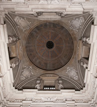 Zdjęcie nr 155: Kaplica zbudowana została na planie kwadratu i nakryta wzniesioną na pendentywach kopułą z latarnią. Przylega do kościoła od północy, do pierwszego przęsła nawy, z którą komunikuje się zamkniętym półkoliście przejściem. Wnętrze artykułowane jest w oparciu o schemat starożytnego łuku triumfalnego za pomocą osadzonych na wysokim cokole pilastrów z kompozytowymi głowicami. Pilastry podtrzymują wydatne belkowanie, ozodbione dekoracją stiukową w postaci puttów, festonów owocowych, rozet oraz kartuszy. Równocześnie pilastry ujmują półkoliste arkady, dwie niższe i większą, środkową. Niższe arkady wypełniają obrazy ze scenami z życia św. Karola Boromeusza. Ponad nimi w prostokątnych, stiukowych, obramieniach znajdują się malowane przedstawienia różnych świętych. W środkowej arkadzie ściany północnej umieszczono okazały późnobarokowy ołtarz z cudownym wizerunkiem św. Karola Boromeusza. Z kolei w arkadach wschodniej i zachodniej rozmieszczono prostokątne okna. Poniżej okna w arkadzie zachodniej znajduje się wyjście na zewnątrz kaplicy zaopatrzone w metalowe, prostokątne drzwi. Natomiast pod oknem w ścianie wschodniej zawieszono tablicę pamiątkową ku czci papieża Jana Pawła II. Arkadę wejściową do kaplicy zamyka prostokątna, brązowa krata. W jej podłuczu od wnętrza na wzór tympanonu umieszczono stiukowy kartusz z herbem Szreniawa, podtrzymywany przez dwa anioły. Ściany tarczowe podniebia przepruto czworobocznymi oknami ujętymi w stiukowe obramienia wolutowe. Na pendentywach przedstawiono w czterech stiukowych kartuszach herby: Szreniawa, Gryf i Kotwicz. Czwarty kartusz jest pusty. Czaszę kopuły wypełnia iluzjonistycznie malowana architektura podzielona na dwie strefy. Dolną artykułują pary pilastrów ujmujące okulusy oraz tralkowa balustrada, a górną gurty wyznaczające pola dla dekoracji ornamentalnej. Ściany zewnętrzne kaplicy zostały podzielone za pomocą kamiennych gzymsów i lizen na dwie trójosiowe kondygnacje, z których górna odpowiada wysokością smukłemu cokołowi mieszczącemu wejście. Zewnętrzne pola każdej elewacji dekorowane są płaskimi pasami tynku w układzie wzoru geometrycznego, zbliżonego do okuciowego. Okna i portal zostały ujęte w profilowane kamienne obramienia. Na ścianie północnej w środkowej kondygnacji pod kartuszem z herbem Szreniawa umieszczono tablicę fundacyjną z napisem: STANISLAUS COMES IN WIŚNICZ LUBOMIRSKI / PALATINUS ET GENERALIS CRACOVIEN[SIS] / SCEPUSIEN[SIS], BIALLOCERKIEVIEN[SIS] / ZATHORIEN[SIS], NIEPOLOMICIEN[SIS] E[T]C[ETER]A, E[T]C[ETER]A, CAPITANEUS / CAPELLAM HANC, / S[ANCTO] CAROLO BARRHOMAEO SUO TUTELARI PATRONO / POST RECEPTA SA[N]CTI HUIUS MERITIS TOT BENEFICIA / DICATAM / EX FUNDAMENTIS EREXIT, DONAVIT / EXORNAVIT, / ANNO D[O]MI[NI], 1640 (Stanisław hrabia na Wiśniczu Lubomirski wojewoda i starosta generalny krakowski, starosta spiski, białocerkiewski, zatorski, niepołomicki, i tak dalej, i tak dalej, tę kaplicę, poświęconą św. Karolowi Boromeuszowi, swojemu patronowi opiekuńczemu, po otrzymaniu tak wielkich łask za wstawiennictwem tego świetego, od fundamentów wzniósł, uposażył i ozdobił, roku Pańskiego 1640). Dach kaplicy oraz latarnia pokryte są blachą miedzianą.
