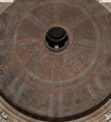 Zdjęcie nr 153: Kaplica zbudowana została na planie kwadratu i nakryta wzniesioną na pendentywach kopułą z latarnią. Przylega do kościoła od północy, do pierwszego przęsła nawy, z którą komunikuje się zamkniętym półkoliście przejściem. Wnętrze artykułowane jest w oparciu o schemat starożytnego łuku triumfalnego za pomocą osadzonych na wysokim cokole pilastrów z kompozytowymi głowicami. Pilastry podtrzymują wydatne belkowanie, ozodbione dekoracją stiukową w postaci puttów, festonów owocowych, rozet oraz kartuszy. Równocześnie pilastry ujmują półkoliste arkady, dwie niższe i większą, środkową. Niższe arkady wypełniają obrazy ze scenami z życia św. Karola Boromeusza. Ponad nimi w prostokątnych, stiukowych, obramieniach znajdują się malowane przedstawienia różnych świętych. W środkowej arkadzie ściany północnej umieszczono okazały późnobarokowy ołtarz z cudownym wizerunkiem św. Karola Boromeusza. Z kolei w arkadach wschodniej i zachodniej rozmieszczono prostokątne okna. Poniżej okna w arkadzie zachodniej znajduje się wyjście na zewnątrz kaplicy zaopatrzone w metalowe, prostokątne drzwi. Natomiast pod oknem w ścianie wschodniej zawieszono tablicę pamiątkową ku czci papieża Jana Pawła II. Arkadę wejściową do kaplicy zamyka prostokątna, brązowa krata. W jej podłuczu od wnętrza na wzór tympanonu umieszczono stiukowy kartusz z herbem Szreniawa, podtrzymywany przez dwa anioły. Ściany tarczowe podniebia przepruto czworobocznymi oknami ujętymi w stiukowe obramienia wolutowe. Na pendentywach przedstawiono w czterech stiukowych kartuszach herby: Szreniawa, Gryf i Kotwicz. Czwarty kartusz jest pusty. Czaszę kopuły wypełnia iluzjonistycznie malowana architektura podzielona na dwie strefy. Dolną artykułują pary pilastrów ujmujące okulusy oraz tralkowa balustrada, a górną gurty wyznaczające pola dla dekoracji ornamentalnej. Ściany zewnętrzne kaplicy zostały podzielone za pomocą kamiennych gzymsów i lizen na dwie trójosiowe kondygnacje, z których górna odpowiada wysokością smukłemu cokołowi mieszczącemu wejście. Zewnętrzne pola każdej elewacji dekorowane są płaskimi pasami tynku w układzie wzoru geometrycznego, zbliżonego do okuciowego. Okna i portal zostały ujęte w profilowane kamienne obramienia. Na ścianie północnej w środkowej kondygnacji pod kartuszem z herbem Szreniawa umieszczono tablicę fundacyjną z napisem: STANISLAUS COMES IN WIŚNICZ LUBOMIRSKI / PALATINUS ET GENERALIS CRACOVIEN[SIS] / SCEPUSIEN[SIS], BIALLOCERKIEVIEN[SIS] / ZATHORIEN[SIS], NIEPOLOMICIEN[SIS] E[T]C[ETER]A, E[T]C[ETER]A, CAPITANEUS / CAPELLAM HANC, / S[ANCTO] CAROLO BARRHOMAEO SUO TUTELARI PATRONO / POST RECEPTA SA[N]CTI HUIUS MERITIS TOT BENEFICIA / DICATAM / EX FUNDAMENTIS EREXIT, DONAVIT / EXORNAVIT, / ANNO D[O]MI[NI], 1640 (Stanisław hrabia na Wiśniczu Lubomirski wojewoda i starosta generalny krakowski, starosta spiski, białocerkiewski, zatorski, niepołomicki, i tak dalej, i tak dalej, tę kaplicę, poświęconą św. Karolowi Boromeuszowi, swojemu patronowi opiekuńczemu, po otrzymaniu tak wielkich łask za wstawiennictwem tego świetego, od fundamentów wzniósł, uposażył i ozdobił, roku Pańskiego 1640). Dach kaplicy oraz latarnia pokryte są blachą miedzianą.
