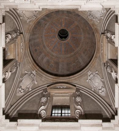 Zdjęcie nr 152: Kaplica zbudowana została na planie kwadratu i nakryta wzniesioną na pendentywach kopułą z latarnią. Przylega do kościoła od północy, do pierwszego przęsła nawy, z którą komunikuje się zamkniętym półkoliście przejściem. Wnętrze artykułowane jest w oparciu o schemat starożytnego łuku triumfalnego za pomocą osadzonych na wysokim cokole pilastrów z kompozytowymi głowicami. Pilastry podtrzymują wydatne belkowanie, ozodbione dekoracją stiukową w postaci puttów, festonów owocowych, rozet oraz kartuszy. Równocześnie pilastry ujmują półkoliste arkady, dwie niższe i większą, środkową. Niższe arkady wypełniają obrazy ze scenami z życia św. Karola Boromeusza. Ponad nimi w prostokątnych, stiukowych, obramieniach znajdują się malowane przedstawienia różnych świętych. W środkowej arkadzie ściany północnej umieszczono okazały późnobarokowy ołtarz z cudownym wizerunkiem św. Karola Boromeusza. Z kolei w arkadach wschodniej i zachodniej rozmieszczono prostokątne okna. Poniżej okna w arkadzie zachodniej znajduje się wyjście na zewnątrz kaplicy zaopatrzone w metalowe, prostokątne drzwi. Natomiast pod oknem w ścianie wschodniej zawieszono tablicę pamiątkową ku czci papieża Jana Pawła II. Arkadę wejściową do kaplicy zamyka prostokątna, brązowa krata. W jej podłuczu od wnętrza na wzór tympanonu umieszczono stiukowy kartusz z herbem Szreniawa, podtrzymywany przez dwa anioły. Ściany tarczowe podniebia przepruto czworobocznymi oknami ujętymi w stiukowe obramienia wolutowe. Na pendentywach przedstawiono w czterech stiukowych kartuszach herby: Szreniawa, Gryf i Kotwicz. Czwarty kartusz jest pusty. Czaszę kopuły wypełnia iluzjonistycznie malowana architektura podzielona na dwie strefy. Dolną artykułują pary pilastrów ujmujące okulusy oraz tralkowa balustrada, a górną gurty wyznaczające pola dla dekoracji ornamentalnej. Ściany zewnętrzne kaplicy zostały podzielone za pomocą kamiennych gzymsów i lizen na dwie trójosiowe kondygnacje, z których górna odpowiada wysokością smukłemu cokołowi mieszczącemu wejście. Zewnętrzne pola każdej elewacji dekorowane są płaskimi pasami tynku w układzie wzoru geometrycznego, zbliżonego do okuciowego. Okna i portal zostały ujęte w profilowane kamienne obramienia. Na ścianie północnej w środkowej kondygnacji pod kartuszem z herbem Szreniawa umieszczono tablicę fundacyjną z napisem: STANISLAUS COMES IN WIŚNICZ LUBOMIRSKI / PALATINUS ET GENERALIS CRACOVIEN[SIS] / SCEPUSIEN[SIS], BIALLOCERKIEVIEN[SIS] / ZATHORIEN[SIS], NIEPOLOMICIEN[SIS] E[T]C[ETER]A, E[T]C[ETER]A, CAPITANEUS / CAPELLAM HANC, / S[ANCTO] CAROLO BARRHOMAEO SUO TUTELARI PATRONO / POST RECEPTA SA[N]CTI HUIUS MERITIS TOT BENEFICIA / DICATAM / EX FUNDAMENTIS EREXIT, DONAVIT / EXORNAVIT, / ANNO D[O]MI[NI], 1640 (Stanisław hrabia na Wiśniczu Lubomirski wojewoda i starosta generalny krakowski, starosta spiski, białocerkiewski, zatorski, niepołomicki, i tak dalej, i tak dalej, tę kaplicę, poświęconą św. Karolowi Boromeuszowi, swojemu patronowi opiekuńczemu, po otrzymaniu tak wielkich łask za wstawiennictwem tego świetego, od fundamentów wzniósł, uposażył i ozdobił, roku Pańskiego 1640). Dach kaplicy oraz latarnia pokryte są blachą miedzianą.
