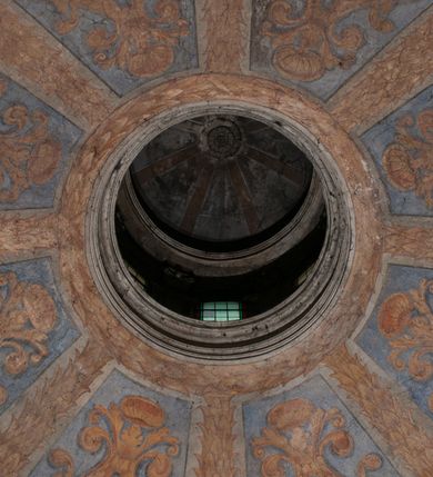 Zdjęcie nr 160: Kaplica zbudowana została na planie kwadratu i nakryta wzniesioną na pendentywach kopułą z latarnią. Przylega do kościoła od północy, do pierwszego przęsła nawy, z którą komunikuje się zamkniętym półkoliście przejściem. Wnętrze artykułowane jest w oparciu o schemat starożytnego łuku triumfalnego za pomocą osadzonych na wysokim cokole pilastrów z kompozytowymi głowicami. Pilastry podtrzymują wydatne belkowanie, ozodbione dekoracją stiukową w postaci puttów, festonów owocowych, rozet oraz kartuszy. Równocześnie pilastry ujmują półkoliste arkady, dwie niższe i większą, środkową. Niższe arkady wypełniają obrazy ze scenami z życia św. Karola Boromeusza. Ponad nimi w prostokątnych, stiukowych, obramieniach znajdują się malowane przedstawienia różnych świętych. W środkowej arkadzie ściany północnej umieszczono okazały późnobarokowy ołtarz z cudownym wizerunkiem św. Karola Boromeusza. Z kolei w arkadach wschodniej i zachodniej rozmieszczono prostokątne okna. Poniżej okna w arkadzie zachodniej znajduje się wyjście na zewnątrz kaplicy zaopatrzone w metalowe, prostokątne drzwi. Natomiast pod oknem w ścianie wschodniej zawieszono tablicę pamiątkową ku czci papieża Jana Pawła II. Arkadę wejściową do kaplicy zamyka prostokątna, brązowa krata. W jej podłuczu od wnętrza na wzór tympanonu umieszczono stiukowy kartusz z herbem Szreniawa, podtrzymywany przez dwa anioły. Ściany tarczowe podniebia przepruto czworobocznymi oknami ujętymi w stiukowe obramienia wolutowe. Na pendentywach przedstawiono w czterech stiukowych kartuszach herby: Szreniawa, Gryf i Kotwicz. Czwarty kartusz jest pusty. Czaszę kopuły wypełnia iluzjonistycznie malowana architektura podzielona na dwie strefy. Dolną artykułują pary pilastrów ujmujące okulusy oraz tralkowa balustrada, a górną gurty wyznaczające pola dla dekoracji ornamentalnej. Ściany zewnętrzne kaplicy zostały podzielone za pomocą kamiennych gzymsów i lizen na dwie trójosiowe kondygnacje, z których górna odpowiada wysokością smukłemu cokołowi mieszczącemu wejście. Zewnętrzne pola każdej elewacji dekorowane są płaskimi pasami tynku w układzie wzoru geometrycznego, zbliżonego do okuciowego. Okna i portal zostały ujęte w profilowane kamienne obramienia. Na ścianie północnej w środkowej kondygnacji pod kartuszem z herbem Szreniawa umieszczono tablicę fundacyjną z napisem: STANISLAUS COMES IN WIŚNICZ LUBOMIRSKI / PALATINUS ET GENERALIS CRACOVIEN[SIS] / SCEPUSIEN[SIS], BIALLOCERKIEVIEN[SIS] / ZATHORIEN[SIS], NIEPOLOMICIEN[SIS] E[T]C[ETER]A, E[T]C[ETER]A, CAPITANEUS / CAPELLAM HANC, / S[ANCTO] CAROLO BARRHOMAEO SUO TUTELARI PATRONO / POST RECEPTA SA[N]CTI HUIUS MERITIS TOT BENEFICIA / DICATAM / EX FUNDAMENTIS EREXIT, DONAVIT / EXORNAVIT, / ANNO D[O]MI[NI], 1640 (Stanisław hrabia na Wiśniczu Lubomirski wojewoda i starosta generalny krakowski, starosta spiski, białocerkiewski, zatorski, niepołomicki, i tak dalej, i tak dalej, tę kaplicę, poświęconą św. Karolowi Boromeuszowi, swojemu patronowi opiekuńczemu, po otrzymaniu tak wielkich łask za wstawiennictwem tego świetego, od fundamentów wzniósł, uposażył i ozdobił, roku Pańskiego 1640). Dach kaplicy oraz latarnia pokryte są blachą miedzianą.
