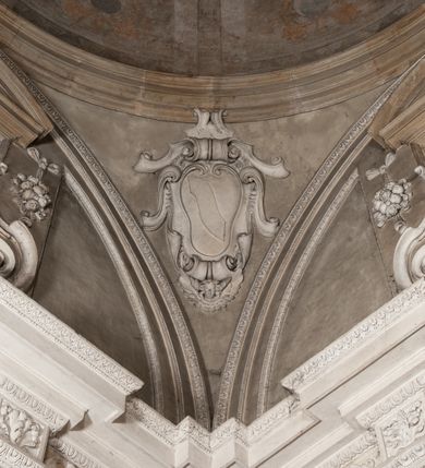 Zdjęcie nr 166: Kaplica zbudowana została na planie kwadratu i nakryta wzniesioną na pendentywach kopułą z latarnią. Przylega do kościoła od północy, do pierwszego przęsła nawy, z którą komunikuje się zamkniętym półkoliście przejściem. Wnętrze artykułowane jest w oparciu o schemat starożytnego łuku triumfalnego za pomocą osadzonych na wysokim cokole pilastrów z kompozytowymi głowicami. Pilastry podtrzymują wydatne belkowanie, ozodbione dekoracją stiukową w postaci puttów, festonów owocowych, rozet oraz kartuszy. Równocześnie pilastry ujmują półkoliste arkady, dwie niższe i większą, środkową. Niższe arkady wypełniają obrazy ze scenami z życia św. Karola Boromeusza. Ponad nimi w prostokątnych, stiukowych, obramieniach znajdują się malowane przedstawienia różnych świętych. W środkowej arkadzie ściany północnej umieszczono okazały późnobarokowy ołtarz z cudownym wizerunkiem św. Karola Boromeusza. Z kolei w arkadach wschodniej i zachodniej rozmieszczono prostokątne okna. Poniżej okna w arkadzie zachodniej znajduje się wyjście na zewnątrz kaplicy zaopatrzone w metalowe, prostokątne drzwi. Natomiast pod oknem w ścianie wschodniej zawieszono tablicę pamiątkową ku czci papieża Jana Pawła II. Arkadę wejściową do kaplicy zamyka prostokątna, brązowa krata. W jej podłuczu od wnętrza na wzór tympanonu umieszczono stiukowy kartusz z herbem Szreniawa, podtrzymywany przez dwa anioły. Ściany tarczowe podniebia przepruto czworobocznymi oknami ujętymi w stiukowe obramienia wolutowe. Na pendentywach przedstawiono w czterech stiukowych kartuszach herby: Szreniawa, Gryf i Kotwicz. Czwarty kartusz jest pusty. Czaszę kopuły wypełnia iluzjonistycznie malowana architektura podzielona na dwie strefy. Dolną artykułują pary pilastrów ujmujące okulusy oraz tralkowa balustrada, a górną gurty wyznaczające pola dla dekoracji ornamentalnej. Ściany zewnętrzne kaplicy zostały podzielone za pomocą kamiennych gzymsów i lizen na dwie trójosiowe kondygnacje, z których górna odpowiada wysokością smukłemu cokołowi mieszczącemu wejście. Zewnętrzne pola każdej elewacji dekorowane są płaskimi pasami tynku w układzie wzoru geometrycznego, zbliżonego do okuciowego. Okna i portal zostały ujęte w profilowane kamienne obramienia. Na ścianie północnej w środkowej kondygnacji pod kartuszem z herbem Szreniawa umieszczono tablicę fundacyjną z napisem: STANISLAUS COMES IN WIŚNICZ LUBOMIRSKI / PALATINUS ET GENERALIS CRACOVIEN[SIS] / SCEPUSIEN[SIS], BIALLOCERKIEVIEN[SIS] / ZATHORIEN[SIS], NIEPOLOMICIEN[SIS] E[T]C[ETER]A, E[T]C[ETER]A, CAPITANEUS / CAPELLAM HANC, / S[ANCTO] CAROLO BARRHOMAEO SUO TUTELARI PATRONO / POST RECEPTA SA[N]CTI HUIUS MERITIS TOT BENEFICIA / DICATAM / EX FUNDAMENTIS EREXIT, DONAVIT / EXORNAVIT, / ANNO D[O]MI[NI], 1640 (Stanisław hrabia na Wiśniczu Lubomirski wojewoda i starosta generalny krakowski, starosta spiski, białocerkiewski, zatorski, niepołomicki, i tak dalej, i tak dalej, tę kaplicę, poświęconą św. Karolowi Boromeuszowi, swojemu patronowi opiekuńczemu, po otrzymaniu tak wielkich łask za wstawiennictwem tego świetego, od fundamentów wzniósł, uposażył i ozdobił, roku Pańskiego 1640). Dach kaplicy oraz latarnia pokryte są blachą miedzianą.
