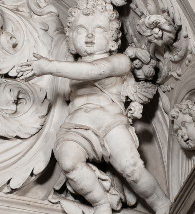 Zdjęcie nr 102: Kaplica zbudowana została na planie kwadratu i nakryta wzniesioną na pendentywach kopułą z latarnią. Przylega do kościoła od północy, do pierwszego przęsła nawy, z którą komunikuje się zamkniętym półkoliście przejściem. Wnętrze artykułowane jest w oparciu o schemat starożytnego łuku triumfalnego za pomocą osadzonych na wysokim cokole pilastrów z kompozytowymi głowicami. Pilastry podtrzymują wydatne belkowanie, ozodbione dekoracją stiukową w postaci puttów, festonów owocowych, rozet oraz kartuszy. Równocześnie pilastry ujmują półkoliste arkady, dwie niższe i większą, środkową. Niższe arkady wypełniają obrazy ze scenami z życia św. Karola Boromeusza. Ponad nimi w prostokątnych, stiukowych, obramieniach znajdują się malowane przedstawienia różnych świętych. W środkowej arkadzie ściany północnej umieszczono okazały późnobarokowy ołtarz z cudownym wizerunkiem św. Karola Boromeusza. Z kolei w arkadach wschodniej i zachodniej rozmieszczono prostokątne okna. Poniżej okna w arkadzie zachodniej znajduje się wyjście na zewnątrz kaplicy zaopatrzone w metalowe, prostokątne drzwi. Natomiast pod oknem w ścianie wschodniej zawieszono tablicę pamiątkową ku czci papieża Jana Pawła II. Arkadę wejściową do kaplicy zamyka prostokątna, brązowa krata. W jej podłuczu od wnętrza na wzór tympanonu umieszczono stiukowy kartusz z herbem Szreniawa, podtrzymywany przez dwa anioły. Ściany tarczowe podniebia przepruto czworobocznymi oknami ujętymi w stiukowe obramienia wolutowe. Na pendentywach przedstawiono w czterech stiukowych kartuszach herby: Szreniawa, Gryf i Kotwicz. Czwarty kartusz jest pusty. Czaszę kopuły wypełnia iluzjonistycznie malowana architektura podzielona na dwie strefy. Dolną artykułują pary pilastrów ujmujące okulusy oraz tralkowa balustrada, a górną gurty wyznaczające pola dla dekoracji ornamentalnej. Ściany zewnętrzne kaplicy zostały podzielone za pomocą kamiennych gzymsów i lizen na dwie trójosiowe kondygnacje, z których górna odpowiada wysokością smukłemu cokołowi mieszczącemu wejście. Zewnętrzne pola każdej elewacji dekorowane są płaskimi pasami tynku w układzie wzoru geometrycznego, zbliżonego do okuciowego. Okna i portal zostały ujęte w profilowane kamienne obramienia. Na ścianie północnej w środkowej kondygnacji pod kartuszem z herbem Szreniawa umieszczono tablicę fundacyjną z napisem: STANISLAUS COMES IN WIŚNICZ LUBOMIRSKI / PALATINUS ET GENERALIS CRACOVIEN[SIS] / SCEPUSIEN[SIS], BIALLOCERKIEVIEN[SIS] / ZATHORIEN[SIS], NIEPOLOMICIEN[SIS] E[T]C[ETER]A, E[T]C[ETER]A, CAPITANEUS / CAPELLAM HANC, / S[ANCTO] CAROLO BARRHOMAEO SUO TUTELARI PATRONO / POST RECEPTA SA[N]CTI HUIUS MERITIS TOT BENEFICIA / DICATAM / EX FUNDAMENTIS EREXIT, DONAVIT / EXORNAVIT, / ANNO D[O]MI[NI], 1640 (Stanisław hrabia na Wiśniczu Lubomirski wojewoda i starosta generalny krakowski, starosta spiski, białocerkiewski, zatorski, niepołomicki, i tak dalej, i tak dalej, tę kaplicę, poświęconą św. Karolowi Boromeuszowi, swojemu patronowi opiekuńczemu, po otrzymaniu tak wielkich łask za wstawiennictwem tego świetego, od fundamentów wzniósł, uposażył i ozdobił, roku Pańskiego 1640). Dach kaplicy oraz latarnia pokryte są blachą miedzianą.
