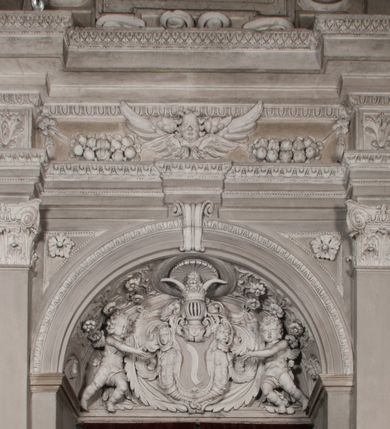 Zdjęcie nr 117: Kaplica zbudowana została na planie kwadratu i nakryta wzniesioną na pendentywach kopułą z latarnią. Przylega do kościoła od północy, do pierwszego przęsła nawy, z którą komunikuje się zamkniętym półkoliście przejściem. Wnętrze artykułowane jest w oparciu o schemat starożytnego łuku triumfalnego za pomocą osadzonych na wysokim cokole pilastrów z kompozytowymi głowicami. Pilastry podtrzymują wydatne belkowanie, ozodbione dekoracją stiukową w postaci puttów, festonów owocowych, rozet oraz kartuszy. Równocześnie pilastry ujmują półkoliste arkady, dwie niższe i większą, środkową. Niższe arkady wypełniają obrazy ze scenami z życia św. Karola Boromeusza. Ponad nimi w prostokątnych, stiukowych, obramieniach znajdują się malowane przedstawienia różnych świętych. W środkowej arkadzie ściany północnej umieszczono okazały późnobarokowy ołtarz z cudownym wizerunkiem św. Karola Boromeusza. Z kolei w arkadach wschodniej i zachodniej rozmieszczono prostokątne okna. Poniżej okna w arkadzie zachodniej znajduje się wyjście na zewnątrz kaplicy zaopatrzone w metalowe, prostokątne drzwi. Natomiast pod oknem w ścianie wschodniej zawieszono tablicę pamiątkową ku czci papieża Jana Pawła II. Arkadę wejściową do kaplicy zamyka prostokątna, brązowa krata. W jej podłuczu od wnętrza na wzór tympanonu umieszczono stiukowy kartusz z herbem Szreniawa, podtrzymywany przez dwa anioły. Ściany tarczowe podniebia przepruto czworobocznymi oknami ujętymi w stiukowe obramienia wolutowe. Na pendentywach przedstawiono w czterech stiukowych kartuszach herby: Szreniawa, Gryf i Kotwicz. Czwarty kartusz jest pusty. Czaszę kopuły wypełnia iluzjonistycznie malowana architektura podzielona na dwie strefy. Dolną artykułują pary pilastrów ujmujące okulusy oraz tralkowa balustrada, a górną gurty wyznaczające pola dla dekoracji ornamentalnej. Ściany zewnętrzne kaplicy zostały podzielone za pomocą kamiennych gzymsów i lizen na dwie trójosiowe kondygnacje, z których górna odpowiada wysokością smukłemu cokołowi mieszczącemu wejście. Zewnętrzne pola każdej elewacji dekorowane są płaskimi pasami tynku w układzie wzoru geometrycznego, zbliżonego do okuciowego. Okna i portal zostały ujęte w profilowane kamienne obramienia. Na ścianie północnej w środkowej kondygnacji pod kartuszem z herbem Szreniawa umieszczono tablicę fundacyjną z napisem: STANISLAUS COMES IN WIŚNICZ LUBOMIRSKI / PALATINUS ET GENERALIS CRACOVIEN[SIS] / SCEPUSIEN[SIS], BIALLOCERKIEVIEN[SIS] / ZATHORIEN[SIS], NIEPOLOMICIEN[SIS] E[T]C[ETER]A, E[T]C[ETER]A, CAPITANEUS / CAPELLAM HANC, / S[ANCTO] CAROLO BARRHOMAEO SUO TUTELARI PATRONO / POST RECEPTA SA[N]CTI HUIUS MERITIS TOT BENEFICIA / DICATAM / EX FUNDAMENTIS EREXIT, DONAVIT / EXORNAVIT, / ANNO D[O]MI[NI], 1640 (Stanisław hrabia na Wiśniczu Lubomirski wojewoda i starosta generalny krakowski, starosta spiski, białocerkiewski, zatorski, niepołomicki, i tak dalej, i tak dalej, tę kaplicę, poświęconą św. Karolowi Boromeuszowi, swojemu patronowi opiekuńczemu, po otrzymaniu tak wielkich łask za wstawiennictwem tego świetego, od fundamentów wzniósł, uposażył i ozdobił, roku Pańskiego 1640). Dach kaplicy oraz latarnia pokryte są blachą miedzianą.
