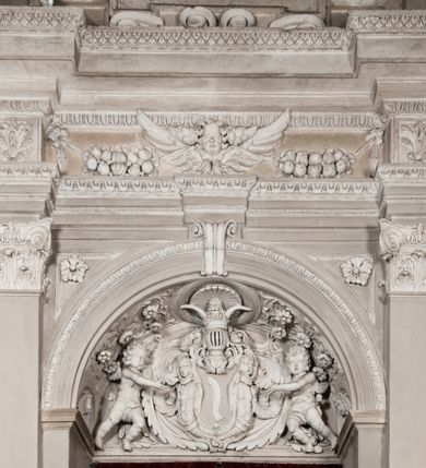 Zdjęcie nr 116: Kaplica zbudowana została na planie kwadratu i nakryta wzniesioną na pendentywach kopułą z latarnią. Przylega do kościoła od północy, do pierwszego przęsła nawy, z którą komunikuje się zamkniętym półkoliście przejściem. Wnętrze artykułowane jest w oparciu o schemat starożytnego łuku triumfalnego za pomocą osadzonych na wysokim cokole pilastrów z kompozytowymi głowicami. Pilastry podtrzymują wydatne belkowanie, ozodbione dekoracją stiukową w postaci puttów, festonów owocowych, rozet oraz kartuszy. Równocześnie pilastry ujmują półkoliste arkady, dwie niższe i większą, środkową. Niższe arkady wypełniają obrazy ze scenami z życia św. Karola Boromeusza. Ponad nimi w prostokątnych, stiukowych, obramieniach znajdują się malowane przedstawienia różnych świętych. W środkowej arkadzie ściany północnej umieszczono okazały późnobarokowy ołtarz z cudownym wizerunkiem św. Karola Boromeusza. Z kolei w arkadach wschodniej i zachodniej rozmieszczono prostokątne okna. Poniżej okna w arkadzie zachodniej znajduje się wyjście na zewnątrz kaplicy zaopatrzone w metalowe, prostokątne drzwi. Natomiast pod oknem w ścianie wschodniej zawieszono tablicę pamiątkową ku czci papieża Jana Pawła II. Arkadę wejściową do kaplicy zamyka prostokątna, brązowa krata. W jej podłuczu od wnętrza na wzór tympanonu umieszczono stiukowy kartusz z herbem Szreniawa, podtrzymywany przez dwa anioły. Ściany tarczowe podniebia przepruto czworobocznymi oknami ujętymi w stiukowe obramienia wolutowe. Na pendentywach przedstawiono w czterech stiukowych kartuszach herby: Szreniawa, Gryf i Kotwicz. Czwarty kartusz jest pusty. Czaszę kopuły wypełnia iluzjonistycznie malowana architektura podzielona na dwie strefy. Dolną artykułują pary pilastrów ujmujące okulusy oraz tralkowa balustrada, a górną gurty wyznaczające pola dla dekoracji ornamentalnej. Ściany zewnętrzne kaplicy zostały podzielone za pomocą kamiennych gzymsów i lizen na dwie trójosiowe kondygnacje, z których górna odpowiada wysokością smukłemu cokołowi mieszczącemu wejście. Zewnętrzne pola każdej elewacji dekorowane są płaskimi pasami tynku w układzie wzoru geometrycznego, zbliżonego do okuciowego. Okna i portal zostały ujęte w profilowane kamienne obramienia. Na ścianie północnej w środkowej kondygnacji pod kartuszem z herbem Szreniawa umieszczono tablicę fundacyjną z napisem: STANISLAUS COMES IN WIŚNICZ LUBOMIRSKI / PALATINUS ET GENERALIS CRACOVIEN[SIS] / SCEPUSIEN[SIS], BIALLOCERKIEVIEN[SIS] / ZATHORIEN[SIS], NIEPOLOMICIEN[SIS] E[T]C[ETER]A, E[T]C[ETER]A, CAPITANEUS / CAPELLAM HANC, / S[ANCTO] CAROLO BARRHOMAEO SUO TUTELARI PATRONO / POST RECEPTA SA[N]CTI HUIUS MERITIS TOT BENEFICIA / DICATAM / EX FUNDAMENTIS EREXIT, DONAVIT / EXORNAVIT, / ANNO D[O]MI[NI], 1640 (Stanisław hrabia na Wiśniczu Lubomirski wojewoda i starosta generalny krakowski, starosta spiski, białocerkiewski, zatorski, niepołomicki, i tak dalej, i tak dalej, tę kaplicę, poświęconą św. Karolowi Boromeuszowi, swojemu patronowi opiekuńczemu, po otrzymaniu tak wielkich łask za wstawiennictwem tego świetego, od fundamentów wzniósł, uposażył i ozdobił, roku Pańskiego 1640). Dach kaplicy oraz latarnia pokryte są blachą miedzianą.
