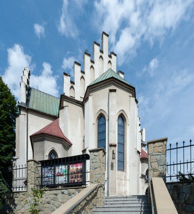 Zdjęcie nr 2: Kościół św. Michała Archanioła jest usytuowany na wysokim wzniesieniu w centrum Mszany Dolnej, na północ od głównej drogi z Raby Niżnej do Kasiny Wielkiej. Teren przykościelny jest otoczony wysokim murem posadowionym na kamiennej podmurówce oraz słupkach z nieregularnych ciosów kamienia i z żeliwnym płotem. W części północnej muru zlokalizowana jest szeroka brama, a od strony południowo-wschodniej na teren przykościelny prowadzą wysokie schody i bramka w murze. 

Kościół jest orientowany, murowany, otynkowany, jednonawowy na rzucie krzyża łacińskiego z czworoboczną wieżą w fasadzie. Wnętrze tworzy wydłużone, zamknięte pięciobocznie, dwuprzęsłowe prezbiterium, które oddziela ściana arkady tęczowej. Nawa jest szersza, czteroprzęsłowa, nakryta sklepieniem krzyżowo-żebrowym. Ramiona transeptu zwyczajowo zwane kaplicami są jednoprzęsłowe, otwarte szerokimi arkadami do nawy. Sklepienie nad skrzyżowaniem nawy z transeptem gwiaździste. Prezbiterium z nawą są połączone szeroką, ostrołukową arkadą w ścianie tęczowej. Od północy i od południa do prezbiterium przylegają dwie zakrystie na planie prostokąta, zamknięte trójbocznie. Wejście do zakrystii zaznaczone wysoką ostrołukową arkadą. Na zachodniej ścianie nawy chór muzyczny, wsparty na dwóch kolumnach, dostępny klatką schodową od nawy. 

Nawę oświetlają umieszczone w południowych i północnych ścianach prostokątne, zamknięte ostrołukowo okna, takie same znajdują się w prezbiterium; w wieży okno koliste w pierwszej kondygnacji, a w wyższych ostrołukowe wąskie okienka zamknięte żaluzjami. Wszystkie okna w nawie i prezbiterium wypełnione są witrażami lub ozdobnymi przeszkleniami. Do kościoła prowadzi główne wejście od strony zachodniej oraz dwa mniejsze w przybudówkach przy zakrystiach.

W zewnętrznej elewacji kościoła widoczny jest niewysoki kamienny cokół, otynkowany. Prezbiterium, niższe od nawy, oszkarpowane. Nawa również oszkarpowana, nakryta dachem dwuspadowym z wieżą na sygnaturkę na skrzyżowaniu nawy z transeptem. Ramiona transeptu od strony północnej i południowej, a także nawa od strony wschodniej zakończone są wysokim szczytami schodkowymi, ze ścianami ozdobionymi ostrołukowymi blendami. Na zachodnim zakończeniu nawy znacznie niższy szczyt schodkowy. Do zachodniej fasady kościoła dostawiona jest wysoka założona na planie kwadratu wieża-dzwonnica w narożach wzmocniona kamiennymi szkarpami. W dolnej kondygnacji, na osi kościoła, prostokątne wejście do kruchty zaakcentowane dwoma stopniami oraz przedsionkiem w kształcie ostrołukowej arkady, zamkniętej dodatkowo trójkątnym szczytem pokrytym blaszanym daszkiem; powyżej rozglifione koliste okno. Po lewej stronie wejścia do kościoła w płytkiej wnęce umieszczone jest popiersie księdza Józefa Stabrawy z tablicą pamiątkową. 

