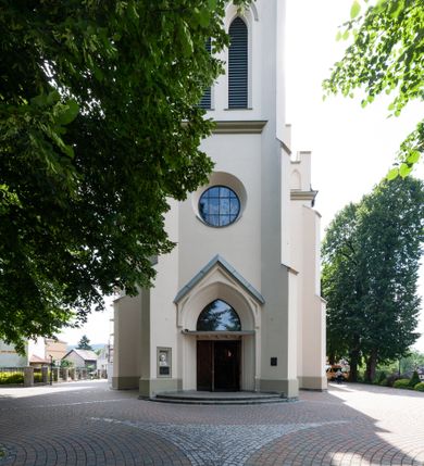 Zdjęcie nr 1: Kościół św. Michała Archanioła jest usytuowany na wysokim wzniesieniu w centrum Mszany Dolnej, na północ od głównej drogi z Raby Niżnej do Kasiny Wielkiej. Teren przykościelny jest otoczony wysokim murem posadowionym na kamiennej podmurówce oraz słupkach z nieregularnych ciosów kamienia i z żeliwnym płotem. W części północnej muru zlokalizowana jest szeroka brama, a od strony południowo-wschodniej na teren przykościelny prowadzą wysokie schody i bramka w murze. 

Kościół jest orientowany, murowany, otynkowany, jednonawowy na rzucie krzyża łacińskiego z czworoboczną wieżą w fasadzie. Wnętrze tworzy wydłużone, zamknięte pięciobocznie, dwuprzęsłowe prezbiterium, które oddziela ściana arkady tęczowej. Nawa jest szersza, czteroprzęsłowa, nakryta sklepieniem krzyżowo-żebrowym. Ramiona transeptu zwyczajowo zwane kaplicami są jednoprzęsłowe, otwarte szerokimi arkadami do nawy. Sklepienie nad skrzyżowaniem nawy z transeptem gwiaździste. Prezbiterium z nawą są połączone szeroką, ostrołukową arkadą w ścianie tęczowej. Od północy i od południa do prezbiterium przylegają dwie zakrystie na planie prostokąta, zamknięte trójbocznie. Wejście do zakrystii zaznaczone wysoką ostrołukową arkadą. Na zachodniej ścianie nawy chór muzyczny, wsparty na dwóch kolumnach, dostępny klatką schodową od nawy. 

Nawę oświetlają umieszczone w południowych i północnych ścianach prostokątne, zamknięte ostrołukowo okna, takie same znajdują się w prezbiterium; w wieży okno koliste w pierwszej kondygnacji, a w wyższych ostrołukowe wąskie okienka zamknięte żaluzjami. Wszystkie okna w nawie i prezbiterium wypełnione są witrażami lub ozdobnymi przeszkleniami. Do kościoła prowadzi główne wejście od strony zachodniej oraz dwa mniejsze w przybudówkach przy zakrystiach.

W zewnętrznej elewacji kościoła widoczny jest niewysoki kamienny cokół, otynkowany. Prezbiterium, niższe od nawy, oszkarpowane. Nawa również oszkarpowana, nakryta dachem dwuspadowym z wieżą na sygnaturkę na skrzyżowaniu nawy z transeptem. Ramiona transeptu od strony północnej i południowej, a także nawa od strony wschodniej zakończone są wysokim szczytami schodkowymi, ze ścianami ozdobionymi ostrołukowymi blendami. Na zachodnim zakończeniu nawy znacznie niższy szczyt schodkowy. Do zachodniej fasady kościoła dostawiona jest wysoka założona na planie kwadratu wieża-dzwonnica w narożach wzmocniona kamiennymi szkarpami. W dolnej kondygnacji, na osi kościoła, prostokątne wejście do kruchty zaakcentowane dwoma stopniami oraz przedsionkiem w kształcie ostrołukowej arkady, zamkniętej dodatkowo trójkątnym szczytem pokrytym blaszanym daszkiem; powyżej rozglifione koliste okno. Po lewej stronie wejścia do kościoła w płytkiej wnęce umieszczone jest popiersie księdza Józefa Stabrawy z tablicą pamiątkową. 


