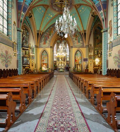 Zdjęcie nr 8: Kościół św. Michała Archanioła jest usytuowany na wysokim wzniesieniu w centrum Mszany Dolnej, na północ od głównej drogi z Raby Niżnej do Kasiny Wielkiej. Teren przykościelny jest otoczony wysokim murem posadowionym na kamiennej podmurówce oraz słupkach z nieregularnych ciosów kamienia i z żeliwnym płotem. W części północnej muru zlokalizowana jest szeroka brama, a od strony południowo-wschodniej na teren przykościelny prowadzą wysokie schody i bramka w murze. 

Kościół jest orientowany, murowany, otynkowany, jednonawowy na rzucie krzyża łacińskiego z czworoboczną wieżą w fasadzie. Wnętrze tworzy wydłużone, zamknięte pięciobocznie, dwuprzęsłowe prezbiterium, które oddziela ściana arkady tęczowej. Nawa jest szersza, czteroprzęsłowa, nakryta sklepieniem krzyżowo-żebrowym. Ramiona transeptu zwyczajowo zwane kaplicami są jednoprzęsłowe, otwarte szerokimi arkadami do nawy. Sklepienie nad skrzyżowaniem nawy z transeptem gwiaździste. Prezbiterium z nawą są połączone szeroką, ostrołukową arkadą w ścianie tęczowej. Od północy i od południa do prezbiterium przylegają dwie zakrystie na planie prostokąta, zamknięte trójbocznie. Wejście do zakrystii zaznaczone wysoką ostrołukową arkadą. Na zachodniej ścianie nawy chór muzyczny, wsparty na dwóch kolumnach, dostępny klatką schodową od nawy. 

Nawę oświetlają umieszczone w południowych i północnych ścianach prostokątne, zamknięte ostrołukowo okna, takie same znajdują się w prezbiterium; w wieży okno koliste w pierwszej kondygnacji, a w wyższych ostrołukowe wąskie okienka zamknięte żaluzjami. Wszystkie okna w nawie i prezbiterium wypełnione są witrażami lub ozdobnymi przeszkleniami. Do kościoła prowadzi główne wejście od strony zachodniej oraz dwa mniejsze w przybudówkach przy zakrystiach.

W zewnętrznej elewacji kościoła widoczny jest niewysoki kamienny cokół, otynkowany. Prezbiterium, niższe od nawy, oszkarpowane. Nawa również oszkarpowana, nakryta dachem dwuspadowym z wieżą na sygnaturkę na skrzyżowaniu nawy z transeptem. Ramiona transeptu od strony północnej i południowej, a także nawa od strony wschodniej zakończone są wysokim szczytami schodkowymi, ze ścianami ozdobionymi ostrołukowymi blendami. Na zachodnim zakończeniu nawy znacznie niższy szczyt schodkowy. Do zachodniej fasady kościoła dostawiona jest wysoka założona na planie kwadratu wieża-dzwonnica w narożach wzmocniona kamiennymi szkarpami. W dolnej kondygnacji, na osi kościoła, prostokątne wejście do kruchty zaakcentowane dwoma stopniami oraz przedsionkiem w kształcie ostrołukowej arkady, zamkniętej dodatkowo trójkątnym szczytem pokrytym blaszanym daszkiem; powyżej rozglifione koliste okno. Po lewej stronie wejścia do kościoła w płytkiej wnęce umieszczone jest popiersie księdza Józefa Stabrawy z tablicą pamiątkową. 

