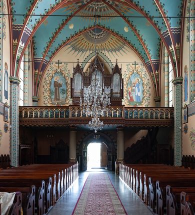 Zdjęcie nr 19: Kościół św. Michała Archanioła jest usytuowany na wysokim wzniesieniu w centrum Mszany Dolnej, na północ od głównej drogi z Raby Niżnej do Kasiny Wielkiej. Teren przykościelny jest otoczony wysokim murem posadowionym na kamiennej podmurówce oraz słupkach z nieregularnych ciosów kamienia i z żeliwnym płotem. W części północnej muru zlokalizowana jest szeroka brama, a od strony południowo-wschodniej na teren przykościelny prowadzą wysokie schody i bramka w murze. 

Kościół jest orientowany, murowany, otynkowany, jednonawowy na rzucie krzyża łacińskiego z czworoboczną wieżą w fasadzie. Wnętrze tworzy wydłużone, zamknięte pięciobocznie, dwuprzęsłowe prezbiterium, które oddziela ściana arkady tęczowej. Nawa jest szersza, czteroprzęsłowa, nakryta sklepieniem krzyżowo-żebrowym. Ramiona transeptu zwyczajowo zwane kaplicami są jednoprzęsłowe, otwarte szerokimi arkadami do nawy. Sklepienie nad skrzyżowaniem nawy z transeptem gwiaździste. Prezbiterium z nawą są połączone szeroką, ostrołukową arkadą w ścianie tęczowej. Od północy i od południa do prezbiterium przylegają dwie zakrystie na planie prostokąta, zamknięte trójbocznie. Wejście do zakrystii zaznaczone wysoką ostrołukową arkadą. Na zachodniej ścianie nawy chór muzyczny, wsparty na dwóch kolumnach, dostępny klatką schodową od nawy. 

Nawę oświetlają umieszczone w południowych i północnych ścianach prostokątne, zamknięte ostrołukowo okna, takie same znajdują się w prezbiterium; w wieży okno koliste w pierwszej kondygnacji, a w wyższych ostrołukowe wąskie okienka zamknięte żaluzjami. Wszystkie okna w nawie i prezbiterium wypełnione są witrażami lub ozdobnymi przeszkleniami. Do kościoła prowadzi główne wejście od strony zachodniej oraz dwa mniejsze w przybudówkach przy zakrystiach.

W zewnętrznej elewacji kościoła widoczny jest niewysoki kamienny cokół, otynkowany. Prezbiterium, niższe od nawy, oszkarpowane. Nawa również oszkarpowana, nakryta dachem dwuspadowym z wieżą na sygnaturkę na skrzyżowaniu nawy z transeptem. Ramiona transeptu od strony północnej i południowej, a także nawa od strony wschodniej zakończone są wysokim szczytami schodkowymi, ze ścianami ozdobionymi ostrołukowymi blendami. Na zachodnim zakończeniu nawy znacznie niższy szczyt schodkowy. Do zachodniej fasady kościoła dostawiona jest wysoka założona na planie kwadratu wieża-dzwonnica w narożach wzmocniona kamiennymi szkarpami. W dolnej kondygnacji, na osi kościoła, prostokątne wejście do kruchty zaakcentowane dwoma stopniami oraz przedsionkiem w kształcie ostrołukowej arkady, zamkniętej dodatkowo trójkątnym szczytem pokrytym blaszanym daszkiem; powyżej rozglifione koliste okno. Po lewej stronie wejścia do kościoła w płytkiej wnęce umieszczone jest popiersie księdza Józefa Stabrawy z tablicą pamiątkową. 

