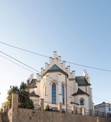 Zdjęcie nr 24: Kościół św. Michała Archanioła jest usytuowany na wysokim wzniesieniu w centrum Mszany Dolnej, na północ od głównej drogi z Raby Niżnej do Kasiny Wielkiej. Teren przykościelny jest otoczony wysokim murem posadowionym na kamiennej podmurówce oraz słupkach z nieregularnych ciosów kamienia i z żeliwnym płotem. W części północnej muru zlokalizowana jest szeroka brama, a od strony południowo-wschodniej na teren przykościelny prowadzą wysokie schody i bramka w murze. 

Kościół jest orientowany, murowany, otynkowany, jednonawowy na rzucie krzyża łacińskiego z czworoboczną wieżą w fasadzie. Wnętrze tworzy wydłużone, zamknięte pięciobocznie, dwuprzęsłowe prezbiterium, które oddziela ściana arkady tęczowej. Nawa jest szersza, czteroprzęsłowa, nakryta sklepieniem krzyżowo-żebrowym. Ramiona transeptu zwyczajowo zwane kaplicami są jednoprzęsłowe, otwarte szerokimi arkadami do nawy. Sklepienie nad skrzyżowaniem nawy z transeptem gwiaździste. Prezbiterium z nawą są połączone szeroką, ostrołukową arkadą w ścianie tęczowej. Od północy i od południa do prezbiterium przylegają dwie zakrystie na planie prostokąta, zamknięte trójbocznie. Wejście do zakrystii zaznaczone wysoką ostrołukową arkadą. Na zachodniej ścianie nawy chór muzyczny, wsparty na dwóch kolumnach, dostępny klatką schodową od nawy. 

Nawę oświetlają umieszczone w południowych i północnych ścianach prostokątne, zamknięte ostrołukowo okna, takie same znajdują się w prezbiterium; w wieży okno koliste w pierwszej kondygnacji, a w wyższych ostrołukowe wąskie okienka zamknięte żaluzjami. Wszystkie okna w nawie i prezbiterium wypełnione są witrażami lub ozdobnymi przeszkleniami. Do kościoła prowadzi główne wejście od strony zachodniej oraz dwa mniejsze w przybudówkach przy zakrystiach.

W zewnętrznej elewacji kościoła widoczny jest niewysoki kamienny cokół, otynkowany. Prezbiterium, niższe od nawy, oszkarpowane. Nawa również oszkarpowana, nakryta dachem dwuspadowym z wieżą na sygnaturkę na skrzyżowaniu nawy z transeptem. Ramiona transeptu od strony północnej i południowej, a także nawa od strony wschodniej zakończone są wysokim szczytami schodkowymi, ze ścianami ozdobionymi ostrołukowymi blendami. Na zachodnim zakończeniu nawy znacznie niższy szczyt schodkowy. Do zachodniej fasady kościoła dostawiona jest wysoka założona na planie kwadratu wieża-dzwonnica w narożach wzmocniona kamiennymi szkarpami. W dolnej kondygnacji, na osi kościoła, prostokątne wejście do kruchty zaakcentowane dwoma stopniami oraz przedsionkiem w kształcie ostrołukowej arkady, zamkniętej dodatkowo trójkątnym szczytem pokrytym blaszanym daszkiem; powyżej rozglifione koliste okno. Po lewej stronie wejścia do kościoła w płytkiej wnęce umieszczone jest popiersie księdza Józefa Stabrawy z tablicą pamiątkową. 

