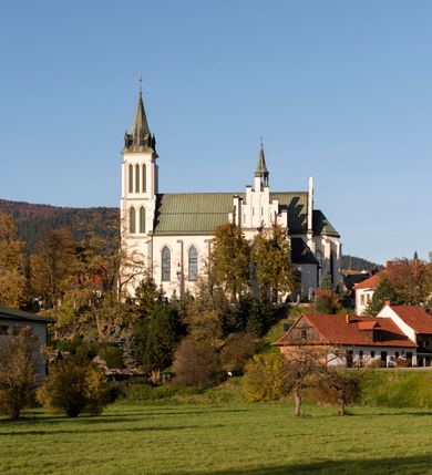 Zdjęcie nr 28: Kościół św. Michała Archanioła jest usytuowany na wysokim wzniesieniu w centrum Mszany Dolnej, na północ od głównej drogi z Raby Niżnej do Kasiny Wielkiej. Teren przykościelny jest otoczony wysokim murem posadowionym na kamiennej podmurówce oraz słupkach z nieregularnych ciosów kamienia i z żeliwnym płotem. W części północnej muru zlokalizowana jest szeroka brama, a od strony południowo-wschodniej na teren przykościelny prowadzą wysokie schody i bramka w murze. 

Kościół jest orientowany, murowany, otynkowany, jednonawowy na rzucie krzyża łacińskiego z czworoboczną wieżą w fasadzie. Wnętrze tworzy wydłużone, zamknięte pięciobocznie, dwuprzęsłowe prezbiterium, które oddziela ściana arkady tęczowej. Nawa jest szersza, czteroprzęsłowa, nakryta sklepieniem krzyżowo-żebrowym. Ramiona transeptu zwyczajowo zwane kaplicami są jednoprzęsłowe, otwarte szerokimi arkadami do nawy. Sklepienie nad skrzyżowaniem nawy z transeptem gwiaździste. Prezbiterium z nawą są połączone szeroką, ostrołukową arkadą w ścianie tęczowej. Od północy i od południa do prezbiterium przylegają dwie zakrystie na planie prostokąta, zamknięte trójbocznie. Wejście do zakrystii zaznaczone wysoką ostrołukową arkadą. Na zachodniej ścianie nawy chór muzyczny, wsparty na dwóch kolumnach, dostępny klatką schodową od nawy. 

Nawę oświetlają umieszczone w południowych i północnych ścianach prostokątne, zamknięte ostrołukowo okna, takie same znajdują się w prezbiterium; w wieży okno koliste w pierwszej kondygnacji, a w wyższych ostrołukowe wąskie okienka zamknięte żaluzjami. Wszystkie okna w nawie i prezbiterium wypełnione są witrażami lub ozdobnymi przeszkleniami. Do kościoła prowadzi główne wejście od strony zachodniej oraz dwa mniejsze w przybudówkach przy zakrystiach.

W zewnętrznej elewacji kościoła widoczny jest niewysoki kamienny cokół, otynkowany. Prezbiterium, niższe od nawy, oszkarpowane. Nawa również oszkarpowana, nakryta dachem dwuspadowym z wieżą na sygnaturkę na skrzyżowaniu nawy z transeptem. Ramiona transeptu od strony północnej i południowej, a także nawa od strony wschodniej zakończone są wysokim szczytami schodkowymi, ze ścianami ozdobionymi ostrołukowymi blendami. Na zachodnim zakończeniu nawy znacznie niższy szczyt schodkowy. Do zachodniej fasady kościoła dostawiona jest wysoka założona na planie kwadratu wieża-dzwonnica w narożach wzmocniona kamiennymi szkarpami. W dolnej kondygnacji, na osi kościoła, prostokątne wejście do kruchty zaakcentowane dwoma stopniami oraz przedsionkiem w kształcie ostrołukowej arkady, zamkniętej dodatkowo trójkątnym szczytem pokrytym blaszanym daszkiem; powyżej rozglifione koliste okno. Po lewej stronie wejścia do kościoła w płytkiej wnęce umieszczone jest popiersie księdza Józefa Stabrawy z tablicą pamiątkową. 

