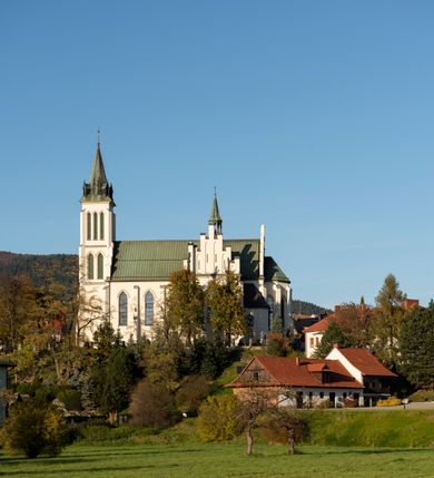 Zdjęcie nr 27: Kościół św. Michała Archanioła jest usytuowany na wysokim wzniesieniu w centrum Mszany Dolnej, na północ od głównej drogi z Raby Niżnej do Kasiny Wielkiej. Teren przykościelny jest otoczony wysokim murem posadowionym na kamiennej podmurówce oraz słupkach z nieregularnych ciosów kamienia i z żeliwnym płotem. W części północnej muru zlokalizowana jest szeroka brama, a od strony południowo-wschodniej na teren przykościelny prowadzą wysokie schody i bramka w murze. 

Kościół jest orientowany, murowany, otynkowany, jednonawowy na rzucie krzyża łacińskiego z czworoboczną wieżą w fasadzie. Wnętrze tworzy wydłużone, zamknięte pięciobocznie, dwuprzęsłowe prezbiterium, które oddziela ściana arkady tęczowej. Nawa jest szersza, czteroprzęsłowa, nakryta sklepieniem krzyżowo-żebrowym. Ramiona transeptu zwyczajowo zwane kaplicami są jednoprzęsłowe, otwarte szerokimi arkadami do nawy. Sklepienie nad skrzyżowaniem nawy z transeptem gwiaździste. Prezbiterium z nawą są połączone szeroką, ostrołukową arkadą w ścianie tęczowej. Od północy i od południa do prezbiterium przylegają dwie zakrystie na planie prostokąta, zamknięte trójbocznie. Wejście do zakrystii zaznaczone wysoką ostrołukową arkadą. Na zachodniej ścianie nawy chór muzyczny, wsparty na dwóch kolumnach, dostępny klatką schodową od nawy. 

Nawę oświetlają umieszczone w południowych i północnych ścianach prostokątne, zamknięte ostrołukowo okna, takie same znajdują się w prezbiterium; w wieży okno koliste w pierwszej kondygnacji, a w wyższych ostrołukowe wąskie okienka zamknięte żaluzjami. Wszystkie okna w nawie i prezbiterium wypełnione są witrażami lub ozdobnymi przeszkleniami. Do kościoła prowadzi główne wejście od strony zachodniej oraz dwa mniejsze w przybudówkach przy zakrystiach.

W zewnętrznej elewacji kościoła widoczny jest niewysoki kamienny cokół, otynkowany. Prezbiterium, niższe od nawy, oszkarpowane. Nawa również oszkarpowana, nakryta dachem dwuspadowym z wieżą na sygnaturkę na skrzyżowaniu nawy z transeptem. Ramiona transeptu od strony północnej i południowej, a także nawa od strony wschodniej zakończone są wysokim szczytami schodkowymi, ze ścianami ozdobionymi ostrołukowymi blendami. Na zachodnim zakończeniu nawy znacznie niższy szczyt schodkowy. Do zachodniej fasady kościoła dostawiona jest wysoka założona na planie kwadratu wieża-dzwonnica w narożach wzmocniona kamiennymi szkarpami. W dolnej kondygnacji, na osi kościoła, prostokątne wejście do kruchty zaakcentowane dwoma stopniami oraz przedsionkiem w kształcie ostrołukowej arkady, zamkniętej dodatkowo trójkątnym szczytem pokrytym blaszanym daszkiem; powyżej rozglifione koliste okno. Po lewej stronie wejścia do kościoła w płytkiej wnęce umieszczone jest popiersie księdza Józefa Stabrawy z tablicą pamiątkową. 

