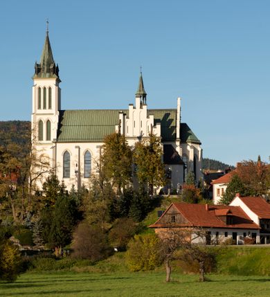 Zdjęcie nr 30: Kościół św. Michała Archanioła jest usytuowany na wysokim wzniesieniu w centrum Mszany Dolnej, na północ od głównej drogi z Raby Niżnej do Kasiny Wielkiej. Teren przykościelny jest otoczony wysokim murem posadowionym na kamiennej podmurówce oraz słupkach z nieregularnych ciosów kamienia i z żeliwnym płotem. W części północnej muru zlokalizowana jest szeroka brama, a od strony południowo-wschodniej na teren przykościelny prowadzą wysokie schody i bramka w murze. 

Kościół jest orientowany, murowany, otynkowany, jednonawowy na rzucie krzyża łacińskiego z czworoboczną wieżą w fasadzie. Wnętrze tworzy wydłużone, zamknięte pięciobocznie, dwuprzęsłowe prezbiterium, które oddziela ściana arkady tęczowej. Nawa jest szersza, czteroprzęsłowa, nakryta sklepieniem krzyżowo-żebrowym. Ramiona transeptu zwyczajowo zwane kaplicami są jednoprzęsłowe, otwarte szerokimi arkadami do nawy. Sklepienie nad skrzyżowaniem nawy z transeptem gwiaździste. Prezbiterium z nawą są połączone szeroką, ostrołukową arkadą w ścianie tęczowej. Od północy i od południa do prezbiterium przylegają dwie zakrystie na planie prostokąta, zamknięte trójbocznie. Wejście do zakrystii zaznaczone wysoką ostrołukową arkadą. Na zachodniej ścianie nawy chór muzyczny, wsparty na dwóch kolumnach, dostępny klatką schodową od nawy. 

Nawę oświetlają umieszczone w południowych i północnych ścianach prostokątne, zamknięte ostrołukowo okna, takie same znajdują się w prezbiterium; w wieży okno koliste w pierwszej kondygnacji, a w wyższych ostrołukowe wąskie okienka zamknięte żaluzjami. Wszystkie okna w nawie i prezbiterium wypełnione są witrażami lub ozdobnymi przeszkleniami. Do kościoła prowadzi główne wejście od strony zachodniej oraz dwa mniejsze w przybudówkach przy zakrystiach.

W zewnętrznej elewacji kościoła widoczny jest niewysoki kamienny cokół, otynkowany. Prezbiterium, niższe od nawy, oszkarpowane. Nawa również oszkarpowana, nakryta dachem dwuspadowym z wieżą na sygnaturkę na skrzyżowaniu nawy z transeptem. Ramiona transeptu od strony północnej i południowej, a także nawa od strony wschodniej zakończone są wysokim szczytami schodkowymi, ze ścianami ozdobionymi ostrołukowymi blendami. Na zachodnim zakończeniu nawy znacznie niższy szczyt schodkowy. Do zachodniej fasady kościoła dostawiona jest wysoka założona na planie kwadratu wieża-dzwonnica w narożach wzmocniona kamiennymi szkarpami. W dolnej kondygnacji, na osi kościoła, prostokątne wejście do kruchty zaakcentowane dwoma stopniami oraz przedsionkiem w kształcie ostrołukowej arkady, zamkniętej dodatkowo trójkątnym szczytem pokrytym blaszanym daszkiem; powyżej rozglifione koliste okno. Po lewej stronie wejścia do kościoła w płytkiej wnęce umieszczone jest popiersie księdza Józefa Stabrawy z tablicą pamiątkową. 

