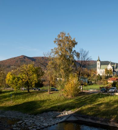 Zdjęcie nr 35: Kościół św. Michała Archanioła jest usytuowany na wysokim wzniesieniu w centrum Mszany Dolnej, na północ od głównej drogi z Raby Niżnej do Kasiny Wielkiej. Teren przykościelny jest otoczony wysokim murem posadowionym na kamiennej podmurówce oraz słupkach z nieregularnych ciosów kamienia i z żeliwnym płotem. W części północnej muru zlokalizowana jest szeroka brama, a od strony południowo-wschodniej na teren przykościelny prowadzą wysokie schody i bramka w murze. 

Kościół jest orientowany, murowany, otynkowany, jednonawowy na rzucie krzyża łacińskiego z czworoboczną wieżą w fasadzie. Wnętrze tworzy wydłużone, zamknięte pięciobocznie, dwuprzęsłowe prezbiterium, które oddziela ściana arkady tęczowej. Nawa jest szersza, czteroprzęsłowa, nakryta sklepieniem krzyżowo-żebrowym. Ramiona transeptu zwyczajowo zwane kaplicami są jednoprzęsłowe, otwarte szerokimi arkadami do nawy. Sklepienie nad skrzyżowaniem nawy z transeptem gwiaździste. Prezbiterium z nawą są połączone szeroką, ostrołukową arkadą w ścianie tęczowej. Od północy i od południa do prezbiterium przylegają dwie zakrystie na planie prostokąta, zamknięte trójbocznie. Wejście do zakrystii zaznaczone wysoką ostrołukową arkadą. Na zachodniej ścianie nawy chór muzyczny, wsparty na dwóch kolumnach, dostępny klatką schodową od nawy. 

Nawę oświetlają umieszczone w południowych i północnych ścianach prostokątne, zamknięte ostrołukowo okna, takie same znajdują się w prezbiterium; w wieży okno koliste w pierwszej kondygnacji, a w wyższych ostrołukowe wąskie okienka zamknięte żaluzjami. Wszystkie okna w nawie i prezbiterium wypełnione są witrażami lub ozdobnymi przeszkleniami. Do kościoła prowadzi główne wejście od strony zachodniej oraz dwa mniejsze w przybudówkach przy zakrystiach.

W zewnętrznej elewacji kościoła widoczny jest niewysoki kamienny cokół, otynkowany. Prezbiterium, niższe od nawy, oszkarpowane. Nawa również oszkarpowana, nakryta dachem dwuspadowym z wieżą na sygnaturkę na skrzyżowaniu nawy z transeptem. Ramiona transeptu od strony północnej i południowej, a także nawa od strony wschodniej zakończone są wysokim szczytami schodkowymi, ze ścianami ozdobionymi ostrołukowymi blendami. Na zachodnim zakończeniu nawy znacznie niższy szczyt schodkowy. Do zachodniej fasady kościoła dostawiona jest wysoka założona na planie kwadratu wieża-dzwonnica w narożach wzmocniona kamiennymi szkarpami. W dolnej kondygnacji, na osi kościoła, prostokątne wejście do kruchty zaakcentowane dwoma stopniami oraz przedsionkiem w kształcie ostrołukowej arkady, zamkniętej dodatkowo trójkątnym szczytem pokrytym blaszanym daszkiem; powyżej rozglifione koliste okno. Po lewej stronie wejścia do kościoła w płytkiej wnęce umieszczone jest popiersie księdza Józefa Stabrawy z tablicą pamiątkową. 

