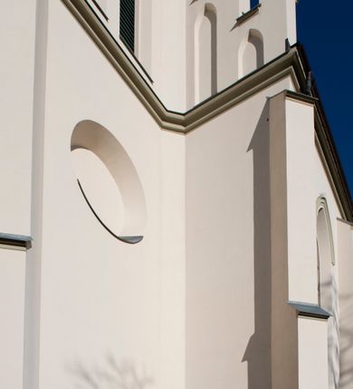 Zdjęcie nr 46: Kościół św. Michała Archanioła jest usytuowany na wysokim wzniesieniu w centrum Mszany Dolnej, na północ od głównej drogi z Raby Niżnej do Kasiny Wielkiej. Teren przykościelny jest otoczony wysokim murem posadowionym na kamiennej podmurówce oraz słupkach z nieregularnych ciosów kamienia i z żeliwnym płotem. W części północnej muru zlokalizowana jest szeroka brama, a od strony południowo-wschodniej na teren przykościelny prowadzą wysokie schody i bramka w murze. 

Kościół jest orientowany, murowany, otynkowany, jednonawowy na rzucie krzyża łacińskiego z czworoboczną wieżą w fasadzie. Wnętrze tworzy wydłużone, zamknięte pięciobocznie, dwuprzęsłowe prezbiterium, które oddziela ściana arkady tęczowej. Nawa jest szersza, czteroprzęsłowa, nakryta sklepieniem krzyżowo-żebrowym. Ramiona transeptu zwyczajowo zwane kaplicami są jednoprzęsłowe, otwarte szerokimi arkadami do nawy. Sklepienie nad skrzyżowaniem nawy z transeptem gwiaździste. Prezbiterium z nawą są połączone szeroką, ostrołukową arkadą w ścianie tęczowej. Od północy i od południa do prezbiterium przylegają dwie zakrystie na planie prostokąta, zamknięte trójbocznie. Wejście do zakrystii zaznaczone wysoką ostrołukową arkadą. Na zachodniej ścianie nawy chór muzyczny, wsparty na dwóch kolumnach, dostępny klatką schodową od nawy. 

Nawę oświetlają umieszczone w południowych i północnych ścianach prostokątne, zamknięte ostrołukowo okna, takie same znajdują się w prezbiterium; w wieży okno koliste w pierwszej kondygnacji, a w wyższych ostrołukowe wąskie okienka zamknięte żaluzjami. Wszystkie okna w nawie i prezbiterium wypełnione są witrażami lub ozdobnymi przeszkleniami. Do kościoła prowadzi główne wejście od strony zachodniej oraz dwa mniejsze w przybudówkach przy zakrystiach.

W zewnętrznej elewacji kościoła widoczny jest niewysoki kamienny cokół, otynkowany. Prezbiterium, niższe od nawy, oszkarpowane. Nawa również oszkarpowana, nakryta dachem dwuspadowym z wieżą na sygnaturkę na skrzyżowaniu nawy z transeptem. Ramiona transeptu od strony północnej i południowej, a także nawa od strony wschodniej zakończone są wysokim szczytami schodkowymi, ze ścianami ozdobionymi ostrołukowymi blendami. Na zachodnim zakończeniu nawy znacznie niższy szczyt schodkowy. Do zachodniej fasady kościoła dostawiona jest wysoka założona na planie kwadratu wieża-dzwonnica w narożach wzmocniona kamiennymi szkarpami. W dolnej kondygnacji, na osi kościoła, prostokątne wejście do kruchty zaakcentowane dwoma stopniami oraz przedsionkiem w kształcie ostrołukowej arkady, zamkniętej dodatkowo trójkątnym szczytem pokrytym blaszanym daszkiem; powyżej rozglifione koliste okno. Po lewej stronie wejścia do kościoła w płytkiej wnęce umieszczone jest popiersie księdza Józefa Stabrawy z tablicą pamiątkową. 

