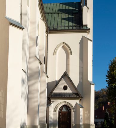 Zdjęcie nr 51: Kościół św. Michała Archanioła jest usytuowany na wysokim wzniesieniu w centrum Mszany Dolnej, na północ od głównej drogi z Raby Niżnej do Kasiny Wielkiej. Teren przykościelny jest otoczony wysokim murem posadowionym na kamiennej podmurówce oraz słupkach z nieregularnych ciosów kamienia i z żeliwnym płotem. W części północnej muru zlokalizowana jest szeroka brama, a od strony południowo-wschodniej na teren przykościelny prowadzą wysokie schody i bramka w murze. 

Kościół jest orientowany, murowany, otynkowany, jednonawowy na rzucie krzyża łacińskiego z czworoboczną wieżą w fasadzie. Wnętrze tworzy wydłużone, zamknięte pięciobocznie, dwuprzęsłowe prezbiterium, które oddziela ściana arkady tęczowej. Nawa jest szersza, czteroprzęsłowa, nakryta sklepieniem krzyżowo-żebrowym. Ramiona transeptu zwyczajowo zwane kaplicami są jednoprzęsłowe, otwarte szerokimi arkadami do nawy. Sklepienie nad skrzyżowaniem nawy z transeptem gwiaździste. Prezbiterium z nawą są połączone szeroką, ostrołukową arkadą w ścianie tęczowej. Od północy i od południa do prezbiterium przylegają dwie zakrystie na planie prostokąta, zamknięte trójbocznie. Wejście do zakrystii zaznaczone wysoką ostrołukową arkadą. Na zachodniej ścianie nawy chór muzyczny, wsparty na dwóch kolumnach, dostępny klatką schodową od nawy. 

Nawę oświetlają umieszczone w południowych i północnych ścianach prostokątne, zamknięte ostrołukowo okna, takie same znajdują się w prezbiterium; w wieży okno koliste w pierwszej kondygnacji, a w wyższych ostrołukowe wąskie okienka zamknięte żaluzjami. Wszystkie okna w nawie i prezbiterium wypełnione są witrażami lub ozdobnymi przeszkleniami. Do kościoła prowadzi główne wejście od strony zachodniej oraz dwa mniejsze w przybudówkach przy zakrystiach.

W zewnętrznej elewacji kościoła widoczny jest niewysoki kamienny cokół, otynkowany. Prezbiterium, niższe od nawy, oszkarpowane. Nawa również oszkarpowana, nakryta dachem dwuspadowym z wieżą na sygnaturkę na skrzyżowaniu nawy z transeptem. Ramiona transeptu od strony północnej i południowej, a także nawa od strony wschodniej zakończone są wysokim szczytami schodkowymi, ze ścianami ozdobionymi ostrołukowymi blendami. Na zachodnim zakończeniu nawy znacznie niższy szczyt schodkowy. Do zachodniej fasady kościoła dostawiona jest wysoka założona na planie kwadratu wieża-dzwonnica w narożach wzmocniona kamiennymi szkarpami. W dolnej kondygnacji, na osi kościoła, prostokątne wejście do kruchty zaakcentowane dwoma stopniami oraz przedsionkiem w kształcie ostrołukowej arkady, zamkniętej dodatkowo trójkątnym szczytem pokrytym blaszanym daszkiem; powyżej rozglifione koliste okno. Po lewej stronie wejścia do kościoła w płytkiej wnęce umieszczone jest popiersie księdza Józefa Stabrawy z tablicą pamiątkową. 

