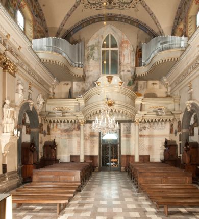 Zdjęcie nr 25: Kościół położony na południe od rynku, na placu otoczonym kamiennym murem z dwiema bramkami od zachodu i północy oraz bramką od południa. Kościół jednonawowy, dwuprzęsłowy, z węższym, niższym dwuprzęsłowym prezbiterium zamkniętym pięciobocznie. Do prezbiterium przylegają dwa aneksy, od północy dawna zakrystia (obecnie kaplica świętych Męczennic), zamknięta od wschodu dwubocznie, mająca w narożu z korpusem wieżyczkę schodową, a od południa zakrystia nowa, na planie prostokąta. Do nawy przylegają dwie kaplice: od północy kaplica Lubomirskich, założona na rzucie kwadratu, nakryta kopułą, a od południa kaplica Branickich, także na rzucie kwadratu z kopułą. Przy korpusie od zachodu piętrowa kruchta, pierwotnie otwarta w przyziemiu od północy, zachodu i południa ostrołukowymi arkadami. Arkada tęczy ostrołukowa. Sklepienie prezbiterium, zakrystii i obu kondygnacjach kruchty krzyżowo-żebrowe, w korpusie, pierwotnie trójprzęsłowym, pierwotnie sklepienie o polach trójkątnych z trójpromieniem, wsparte na dwóch dziesięciobocznych filarach, obecnie kolebkowo z lunetami. Żebra w prezbiterium i zakrystii o profilu żłobkowym, w kruchcie - gruszkowym. W prezbiterium służki cylindryczne, nadwieszone na oplecionych liśćmi wspornikach oraz rzeźbione zworniki z przedstawieniem Głowy Chrystusa i motywami roślinnymi. Ściany rozczłonkowane wykonanymi w czarnego marmuru arkadami, zamkniętymi łukiem półkolistymi. Okna ostrołukowe , obustronnie rozglifione z krzyżowym laskowaniem, w ścianie północnym prezbiterium ślepe. Kościół opięty przyporami. Elewacje na cokole, z profilowanymi gzymsami cokołowymi, kapnikowym i koronującym. Szczyty zwieńczone kwiatonami, z których zachodnie z krzyżem. Portale kamienne, ostrołukowe: zachodni profilowany, z ażurowym maswerkiem; drugi w prezbiterium do zakrystii, profilowany; trzeci do wieżyczki schodowej.