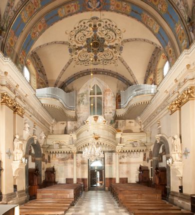 Zdjęcie nr 27: Kościół położony na południe od rynku, na placu otoczonym kamiennym murem z dwiema bramkami od zachodu i północy oraz bramką od południa. Kościół jednonawowy, dwuprzęsłowy, z węższym, niższym dwuprzęsłowym prezbiterium zamkniętym pięciobocznie. Do prezbiterium przylegają dwa aneksy, od północy dawna zakrystia (obecnie kaplica świętych Męczennic), zamknięta od wschodu dwubocznie, mająca w narożu z korpusem wieżyczkę schodową, a od południa zakrystia nowa, na planie prostokąta. Do nawy przylegają dwie kaplice: od północy kaplica Lubomirskich, założona na rzucie kwadratu, nakryta kopułą, a od południa kaplica Branickich, także na rzucie kwadratu z kopułą. Przy korpusie od zachodu piętrowa kruchta, pierwotnie otwarta w przyziemiu od północy, zachodu i południa ostrołukowymi arkadami. Arkada tęczy ostrołukowa. Sklepienie prezbiterium, zakrystii i obu kondygnacjach kruchty krzyżowo-żebrowe, w korpusie, pierwotnie trójprzęsłowym, pierwotnie sklepienie o polach trójkątnych z trójpromieniem, wsparte na dwóch dziesięciobocznych filarach, obecnie kolebkowo z lunetami. Żebra w prezbiterium i zakrystii o profilu żłobkowym, w kruchcie - gruszkowym. W prezbiterium służki cylindryczne, nadwieszone na oplecionych liśćmi wspornikach oraz rzeźbione zworniki z przedstawieniem Głowy Chrystusa i motywami roślinnymi. Ściany rozczłonkowane wykonanymi w czarnego marmuru arkadami, zamkniętymi łukiem półkolistymi. Okna ostrołukowe , obustronnie rozglifione z krzyżowym laskowaniem, w ścianie północnym prezbiterium ślepe. Kościół opięty przyporami. Elewacje na cokole, z profilowanymi gzymsami cokołowymi, kapnikowym i koronującym. Szczyty zwieńczone kwiatonami, z których zachodnie z krzyżem. Portale kamienne, ostrołukowe: zachodni profilowany, z ażurowym maswerkiem; drugi w prezbiterium do zakrystii, profilowany; trzeci do wieżyczki schodowej.